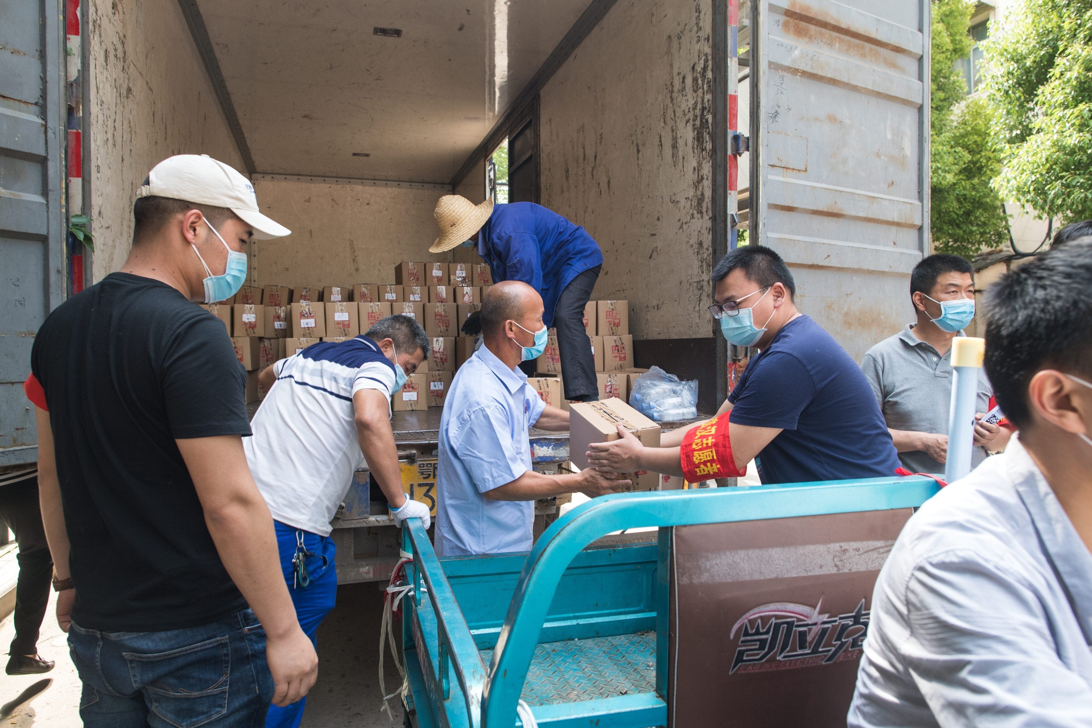 Staff distribute traditional Chinese medicine on Tuesday intended to treat COVID-19 at the Sanmin residential community in Wuhan, China, where six new cases were recently confirmed. (Xiao Yijiu/Xinhua via Zuma via CP)