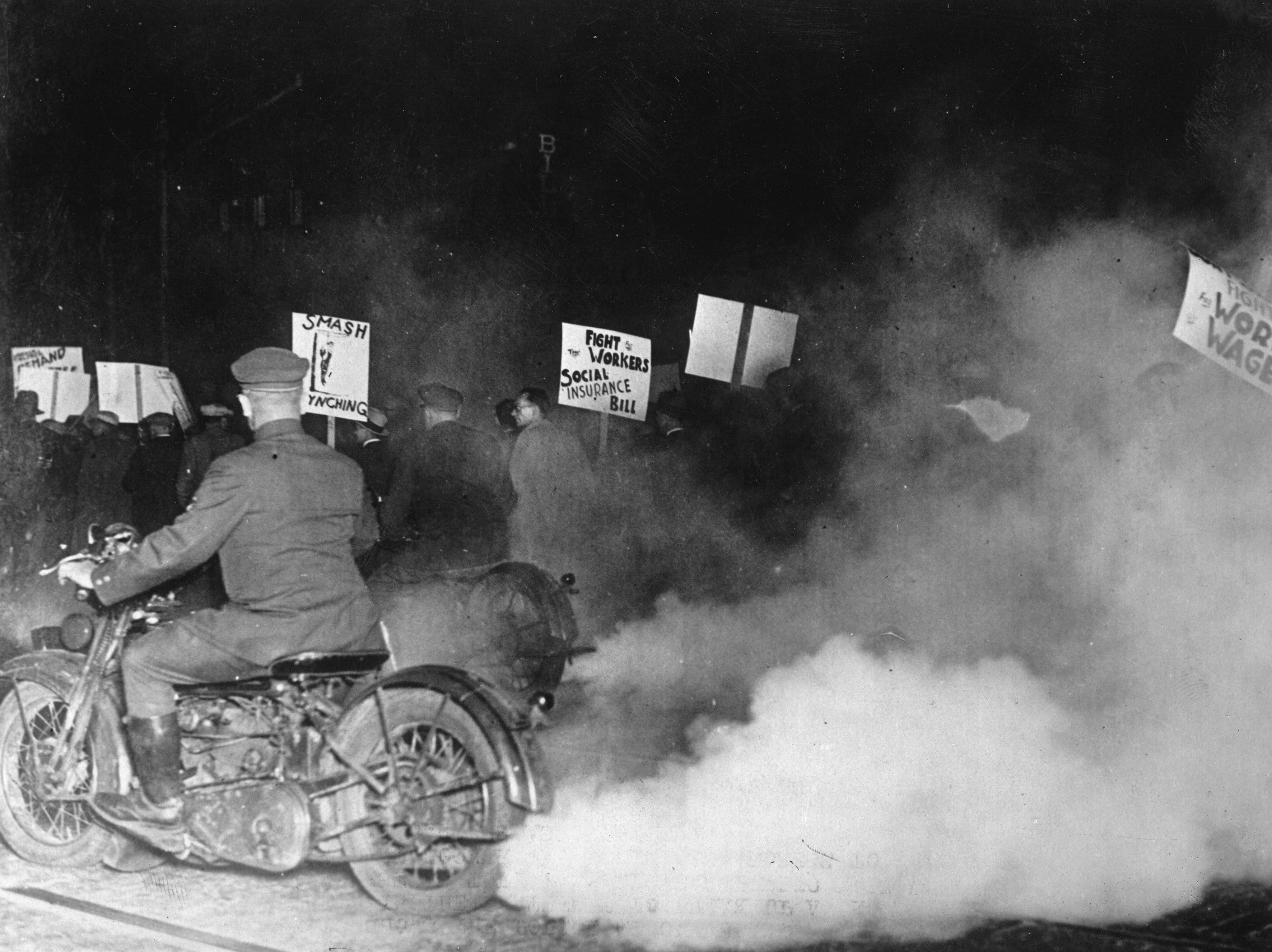 New York police on motorcycles wrap a demonstration in fog to prevent the demonstrators at the march-past in front of a building in which President Herbert Hoover is speaking in New York, 1930. (Photo by Imagno/Hulton Archive/Getty)