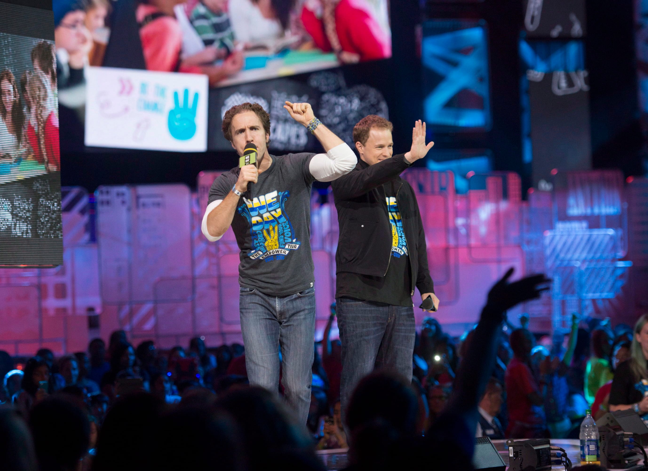 Craig Kielburger and Marc Kielburger speak during We Day in Toronto on Oct. 2, 2014 (CP/Hannah Yoon)