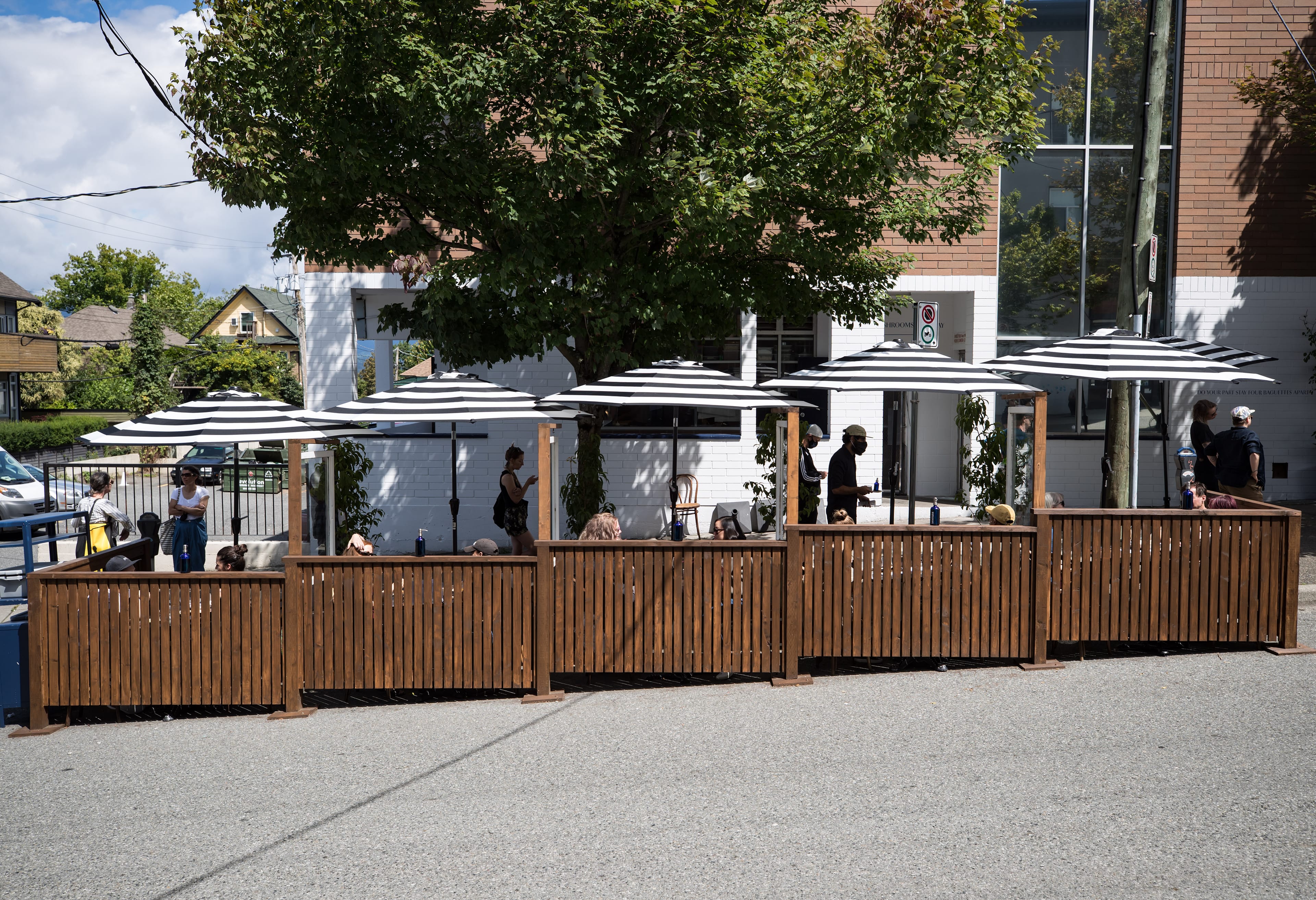 People dine on the patio space at Livia in Vancouver, on Jul. 12, 2020. The City of Vancouver allowed businesses to apply for the temporary patios to help restaurants and customers follow provincial health guidelines for physical distancing due to COVID-19. (Darryl Dyck/CP)