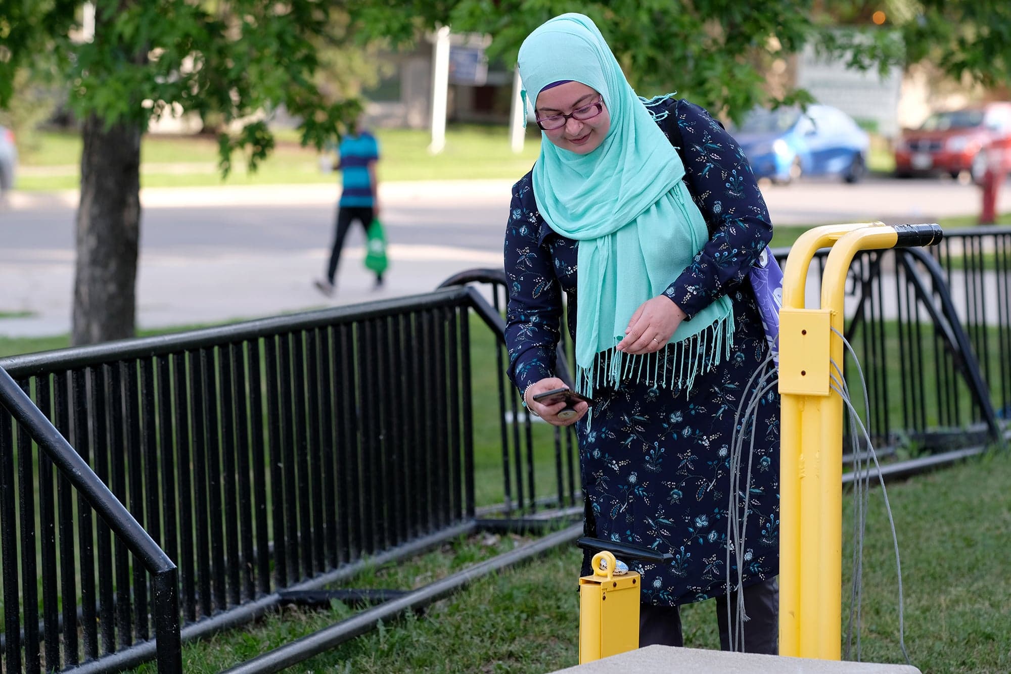 Usmani snaps a photo after placing a kindness rock on a bike repair station in Winnipeg (Photograph by Shannon VanRaes)