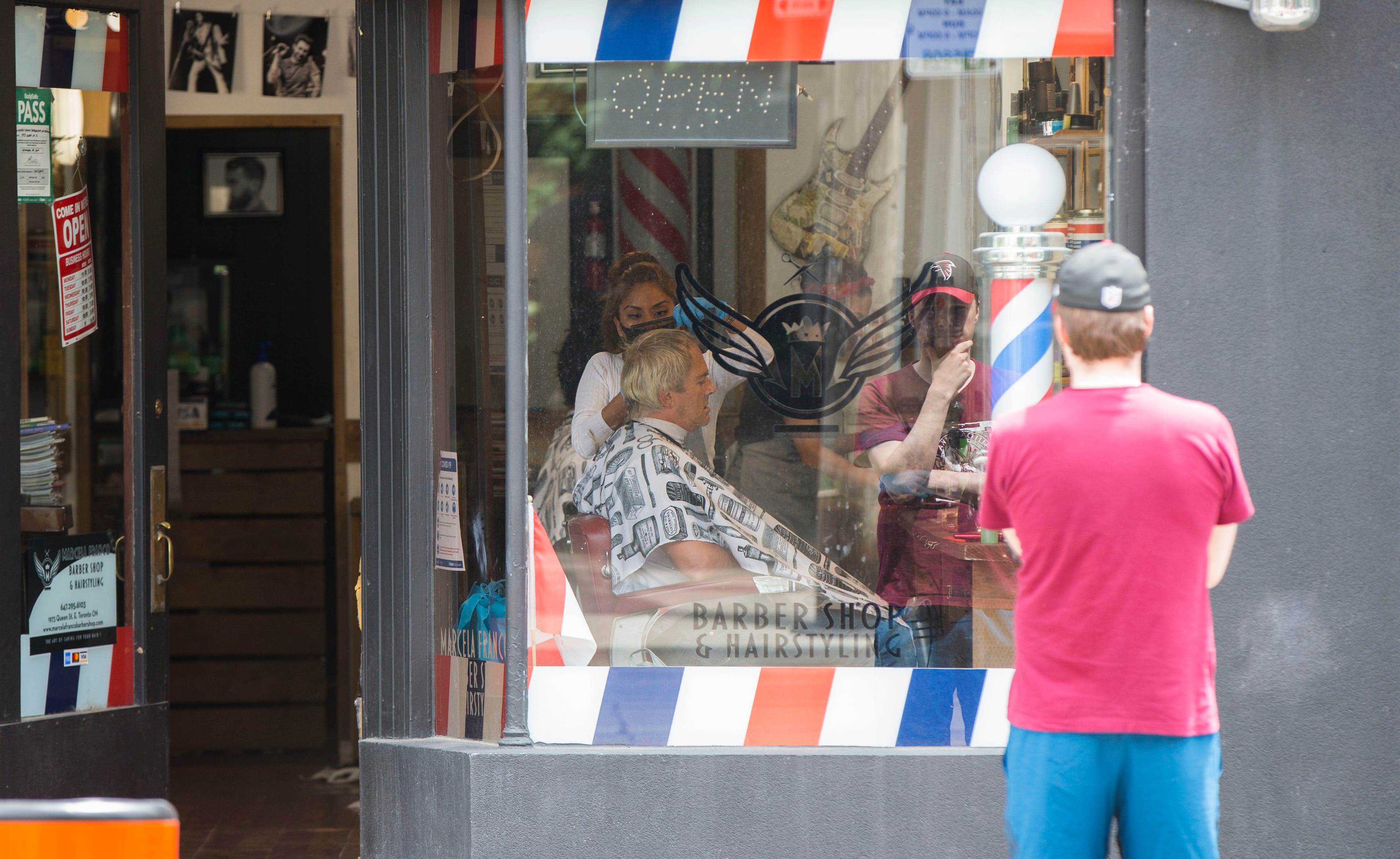 A hairdresser wearing a face mask cuts a man's hair at a hair salon in Toronto, Canada, on Jun. 24, 2020. (CP/ZUMA Wire/Zou Zheng/Xinhua)