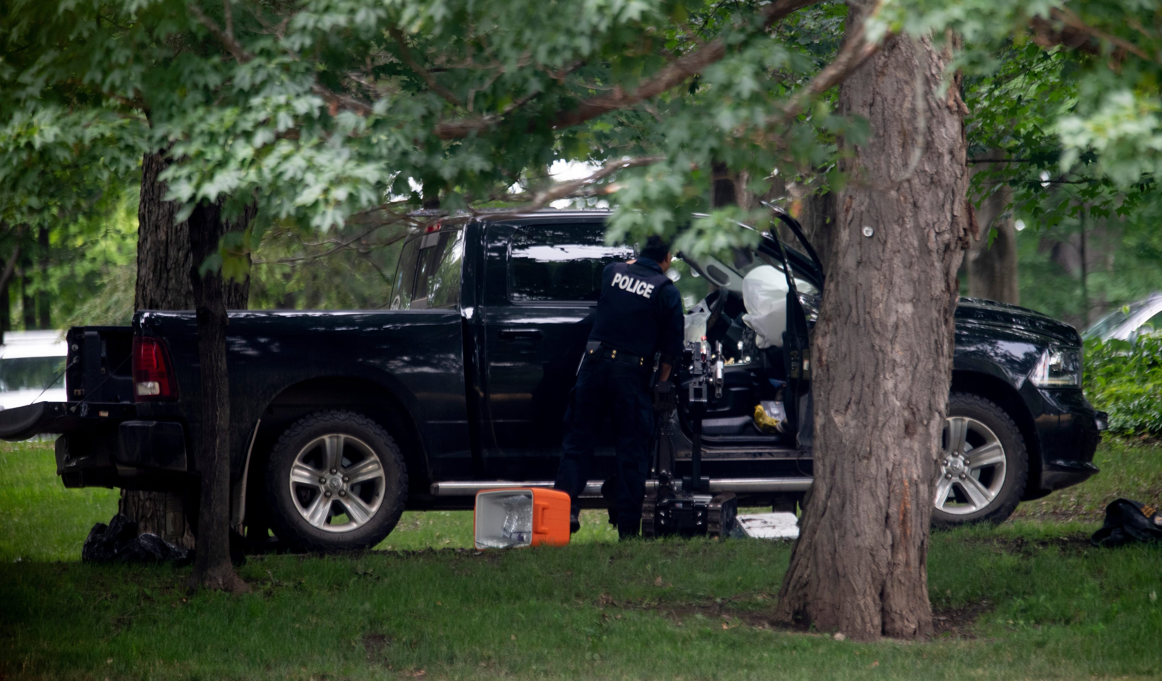 An RCMP police officer looks in the cab of a pickup truck on the grounds of Rideau Hall in Ottawa, Thursday July 2, 2020. (Adrian Wyld)