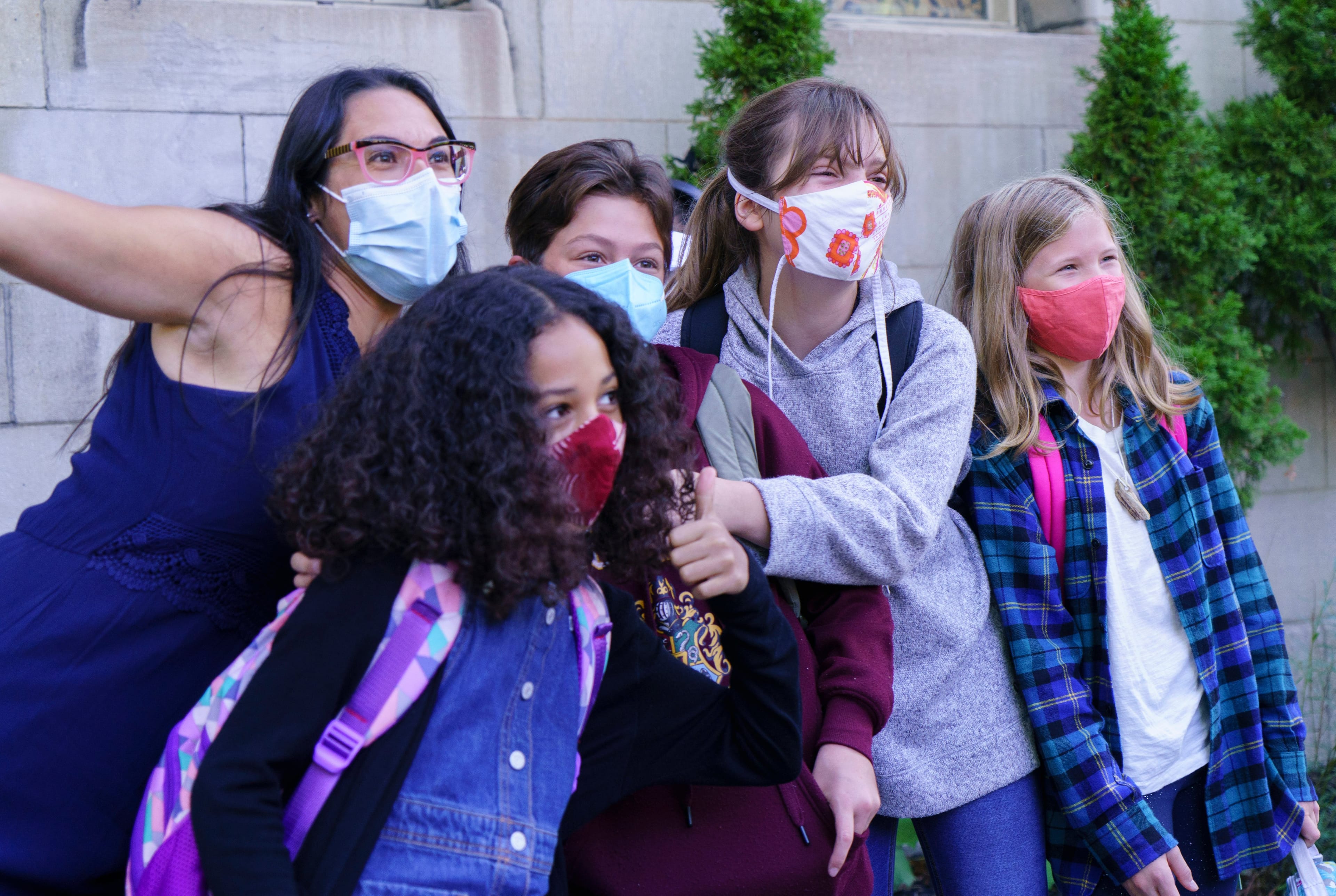 A teacher photo bombs a photo of a group of students reuniting as they go back to school at the Bancroft Elementary School in Montreal, on Aug. 31, 2020. (Paul Chiasson/CP)