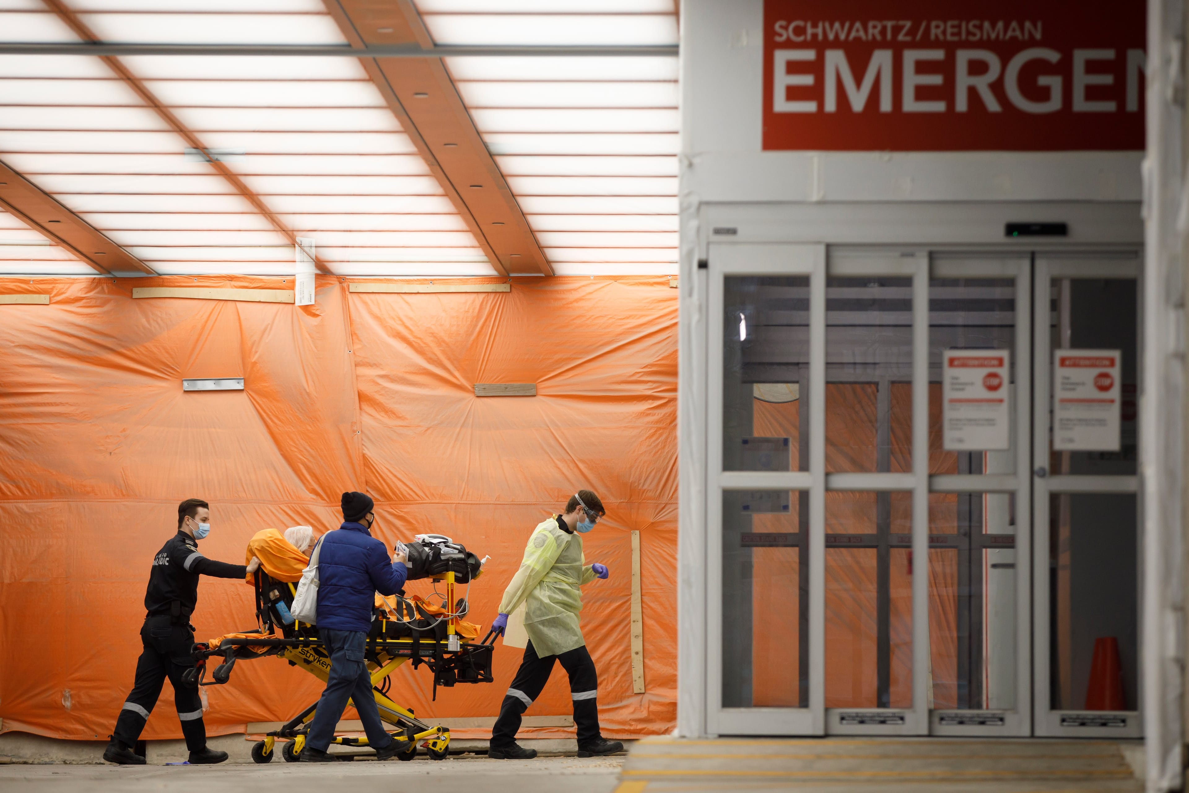 Paramedics wheel a patient into the emergency department at Mount Sinai Hospital in Toronto, on Jan. 13, 2021 (CP/Cole Burston)