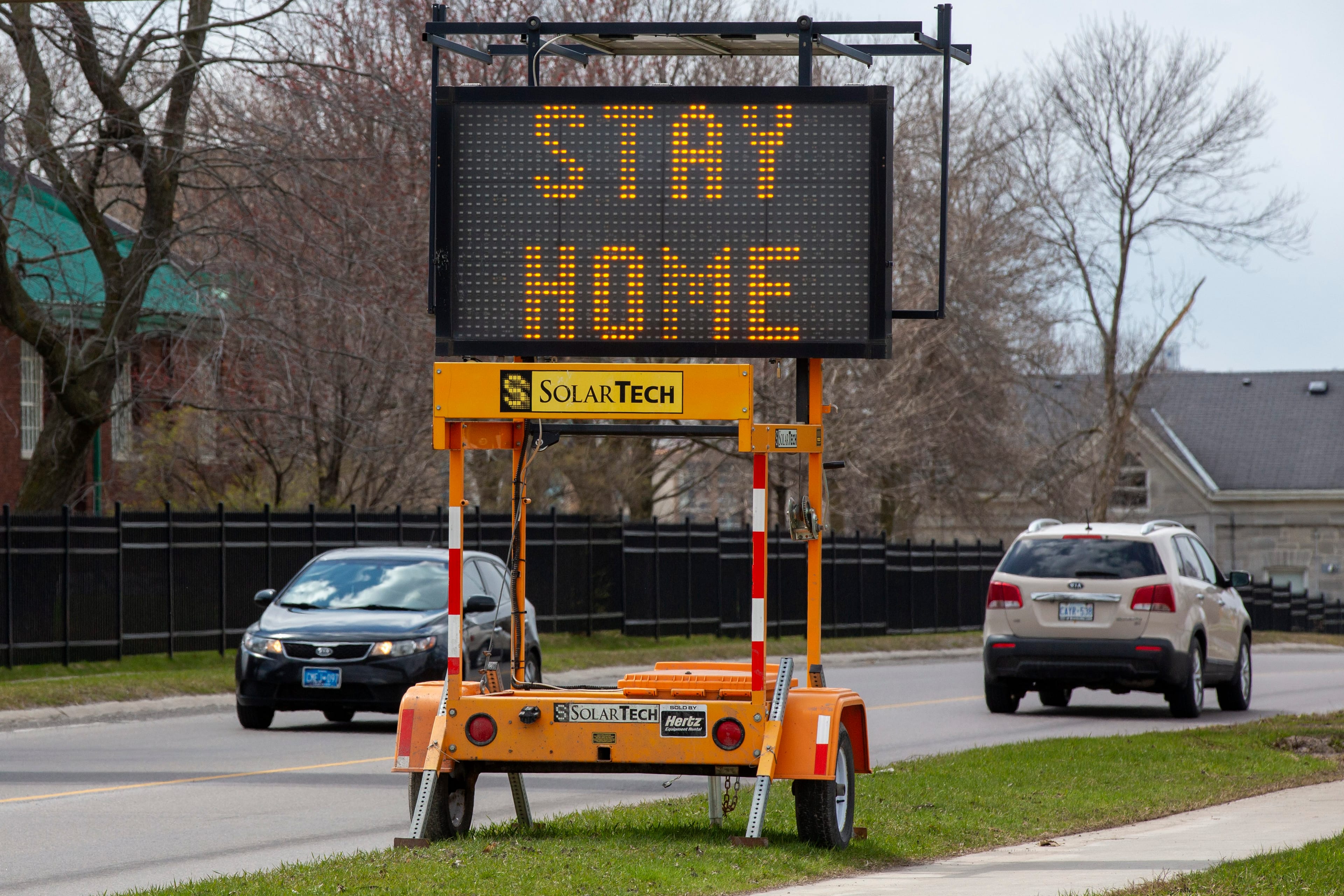 A sign tells people to stay home because of the COVID pandemic, along a road in Kingston, Ont., on April 17, 2020 (CP/Lars Hagberg)