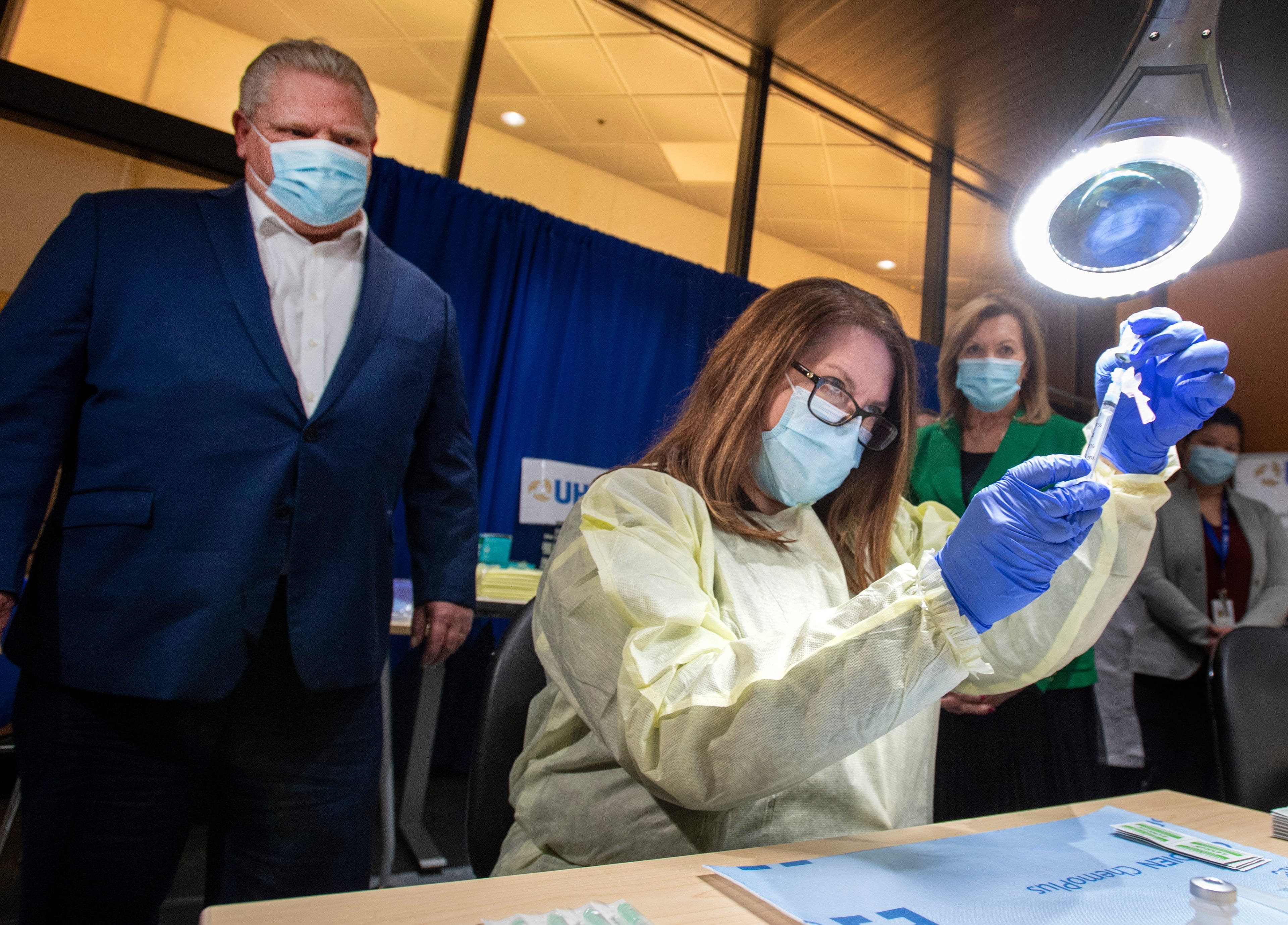 Ontario Premier Doug Ford looks on as a dose of the Pfizer-BioNTech COVID-19 vaccine is prepared by Pharmacy Technician Supervisor Tamara Booth Rumsey at The Michener Institute in Toronto on Monday, January 4, 2021. THE CANADIAN PRESS/Frank Gunn