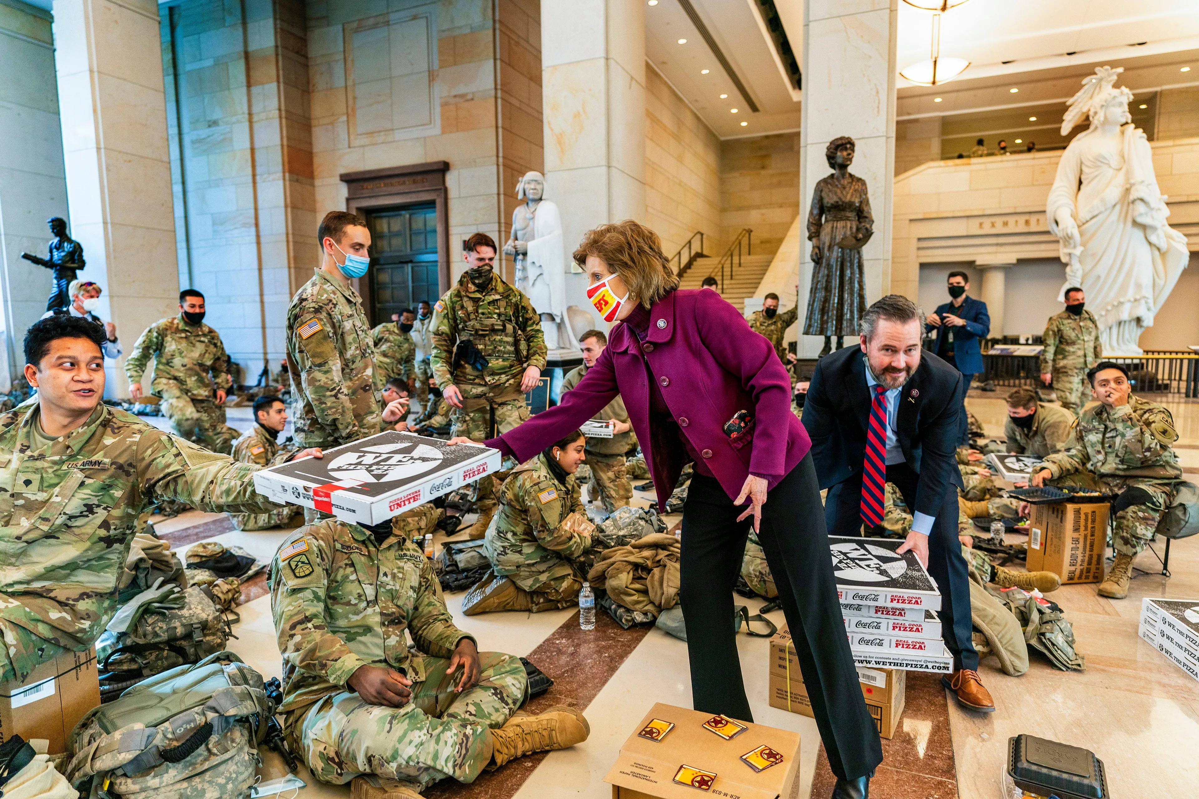 Rep. Vicky Hartzler, R-Mo., and Rep. Michael Waltz, R-Fla., hand pizzas to members of the National Guard gathered at the Capitol Visitor Center, Wednesday, Jan. 13, 2021, in Washington. as the House of Representatives continues with its fast-moving House vote to impeach President Donald Trump, a week after a mob of Trump supporters stormed the U.S. Capitol. (Manuel Balce Ceneta/AP/CP)