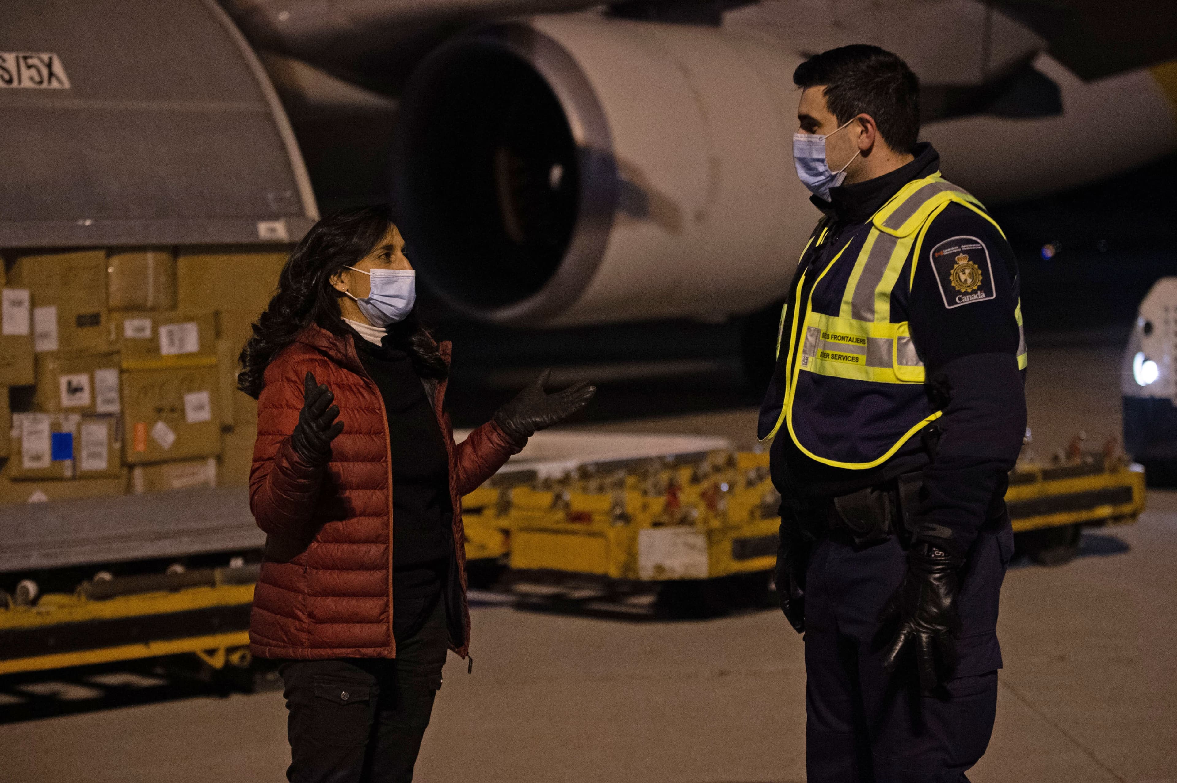 The Honourable Anita Anand, Minister of Public Services and Procurement Canada oversees the off loading of COVID-19 vaccines from a cargo aircraft with members of Canadian Border Services Agency, December 13, 2020. (Courtesy of Cpl Matthew Tower/DND)