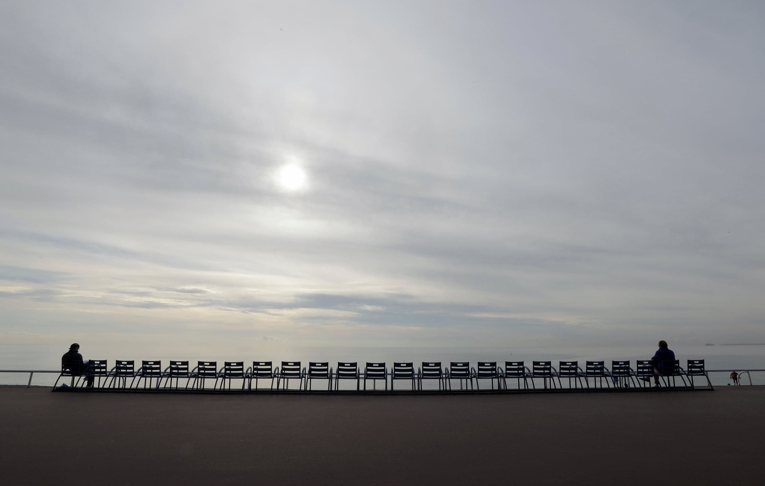 People sit on the blue chairs of the Promenade des Anglais before their removal to avoid public gatherings during the second national lockdown as part of the measures to fight a second wave of the coronavirus disease (COVID-19) in Nice, France, November 12, 2020. (Eric Gaillard/Reuters)