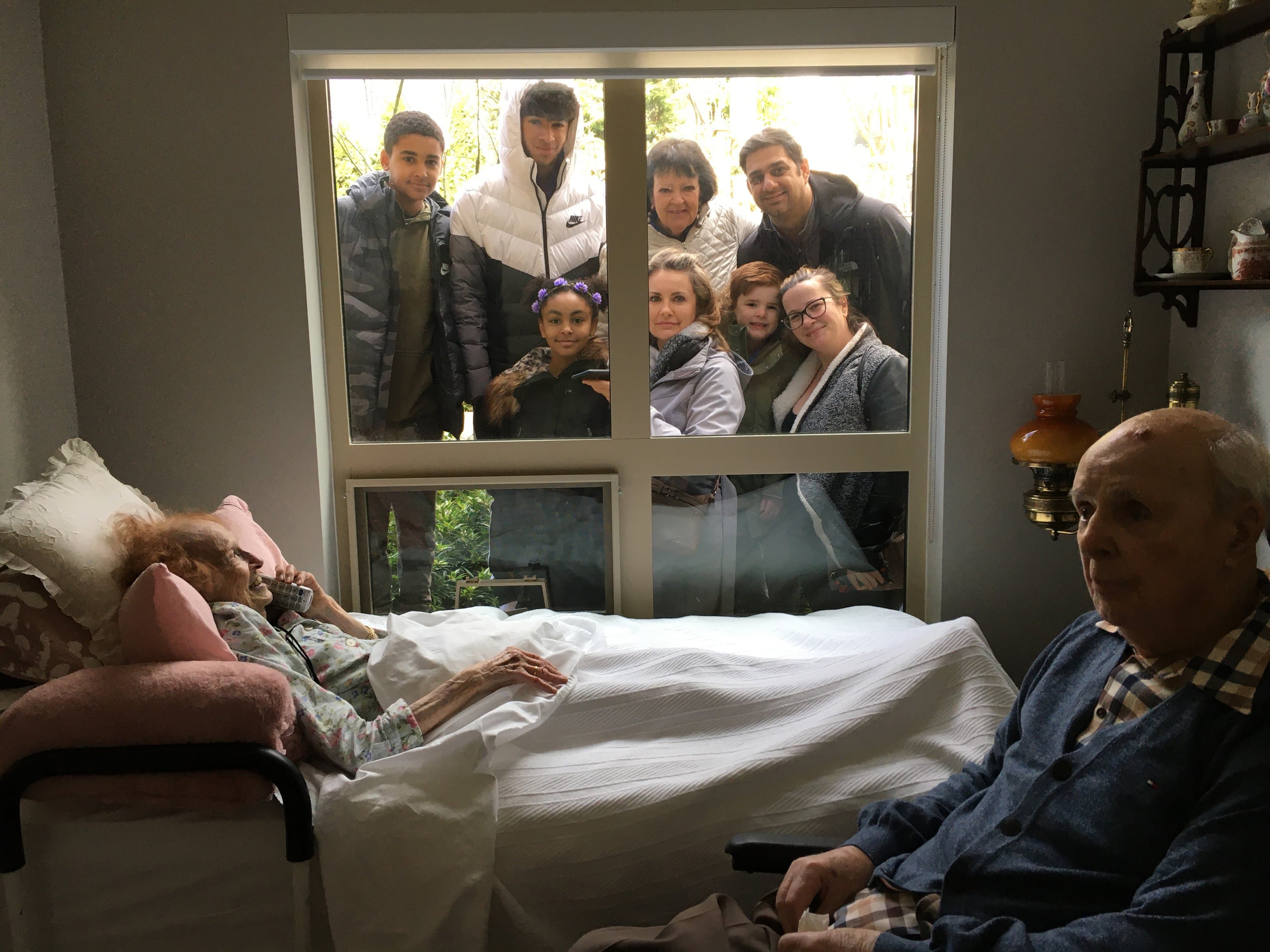 Juanita and Howard Robinson use a phone to speak with family gathered outside the window at their LTC home, on April 3, 2020. Juanita and Howard died within five hours of each other, on April 6, 2020, in North Vancouver. (Courtesy of Sharon Robinson)