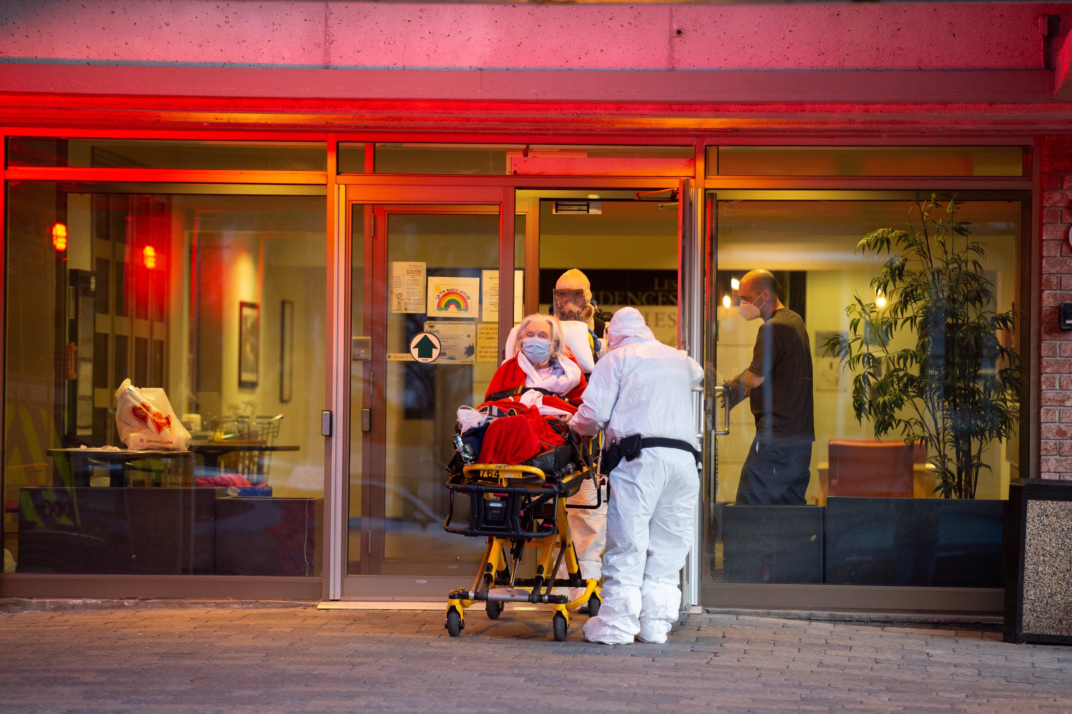 Ambulance attendants wheel a patient out of Floralies LaSalle seniors’ residence in Montreal amid a coronavirus outbreak at the facility (Christinne Muschi)