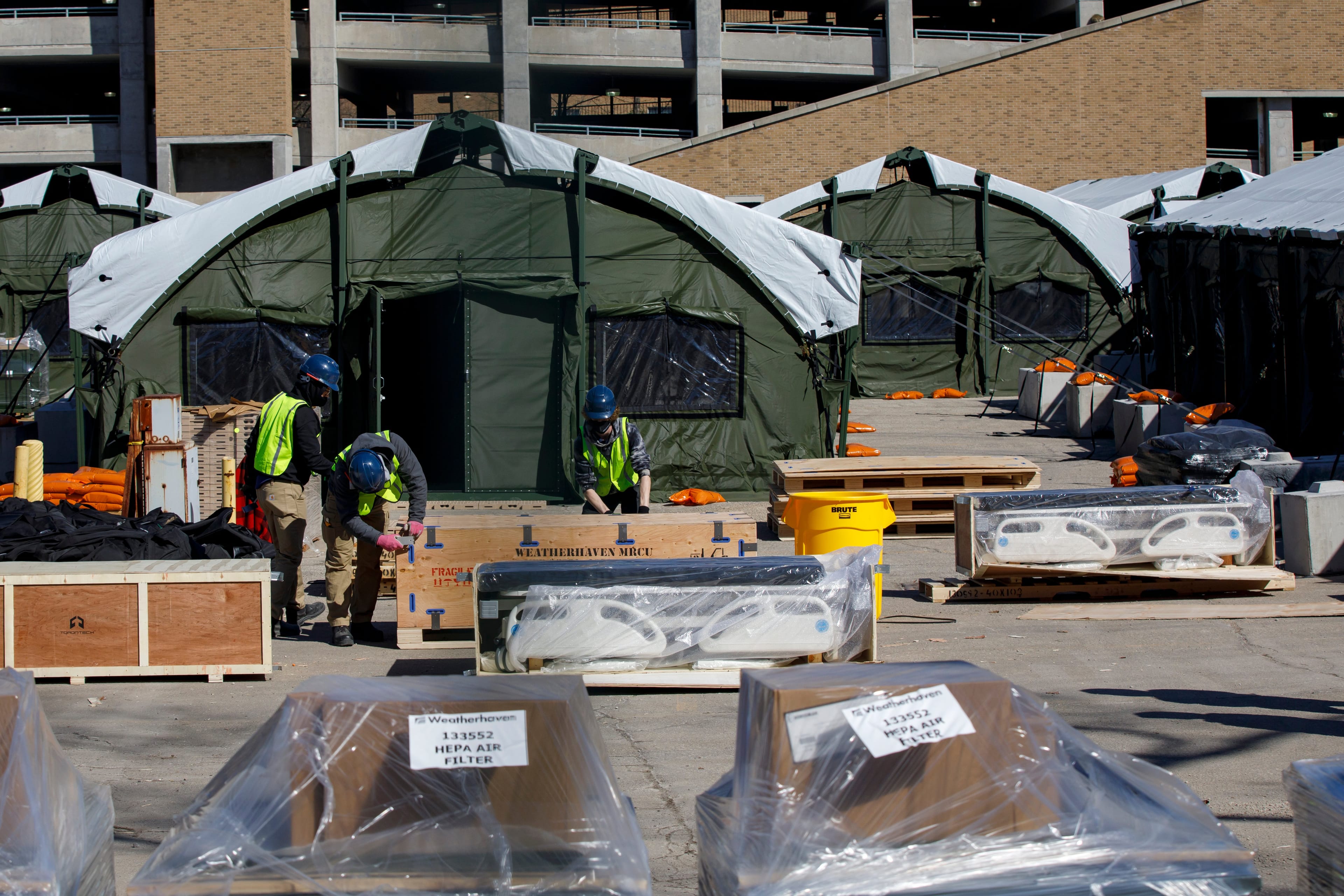 Workers uncrate hospital beds at a field hospital under construction at Sunnybrook Hospital, in Toronto, Sunday, March 14, 2021. THE CANADIAN PRESS/Cole Burston