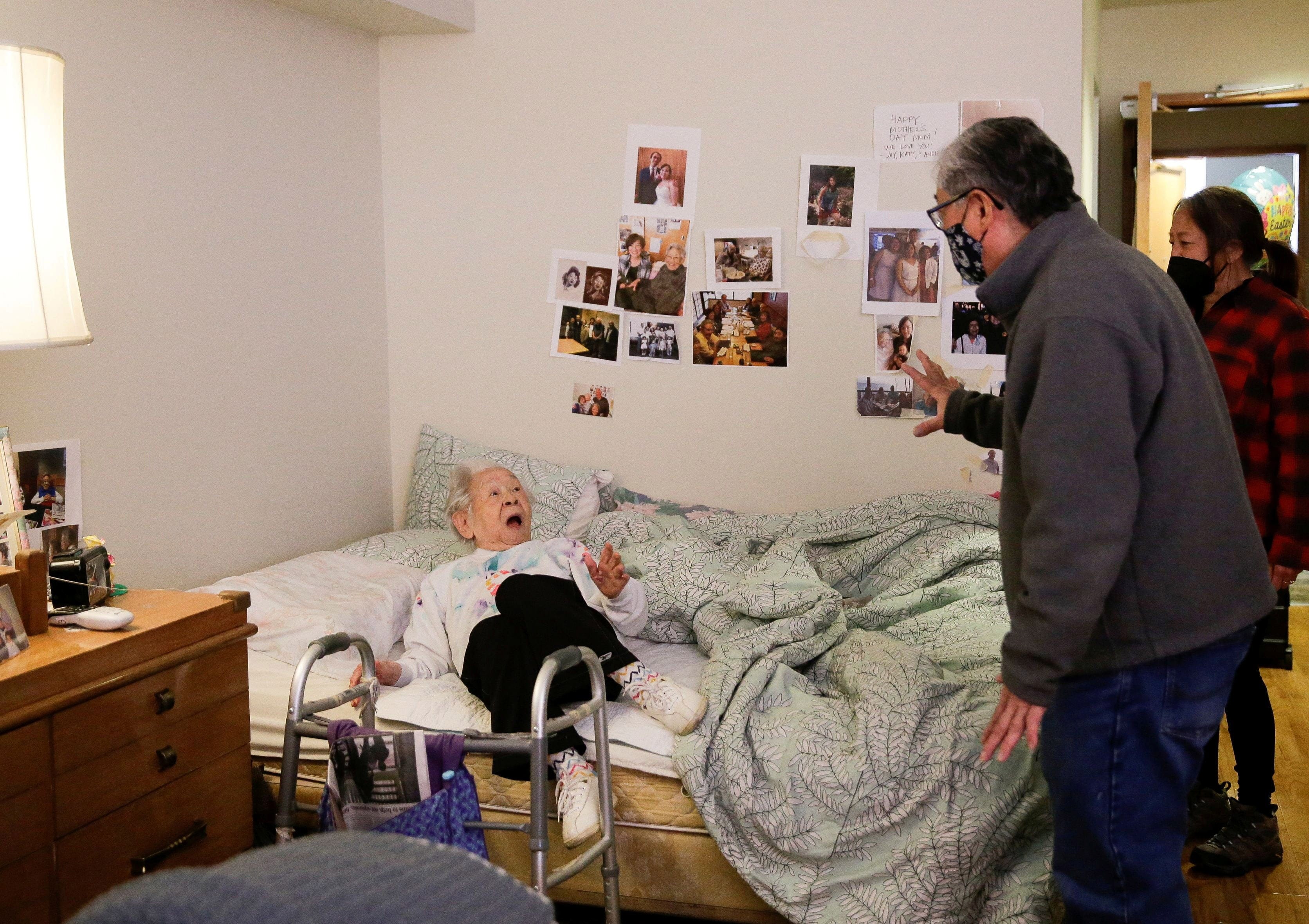 Yoshia Uomoto, 98, reacts as her son Mark Uomoto and niece Gail Yamada surprise her with their first in-person visit in a year after indoor visitation restrictions due to the coronavirus disease (COVID-19) were lifted at Nikkei Manor, an assisted living facility primarily serving Japanese-American seniors, in Seattle, Washington, U.S. March 30, 2021. Residents, who have all been fully vaccinated, can visit with family for an hour at a time. (Lindsey Wasson/Reuters)