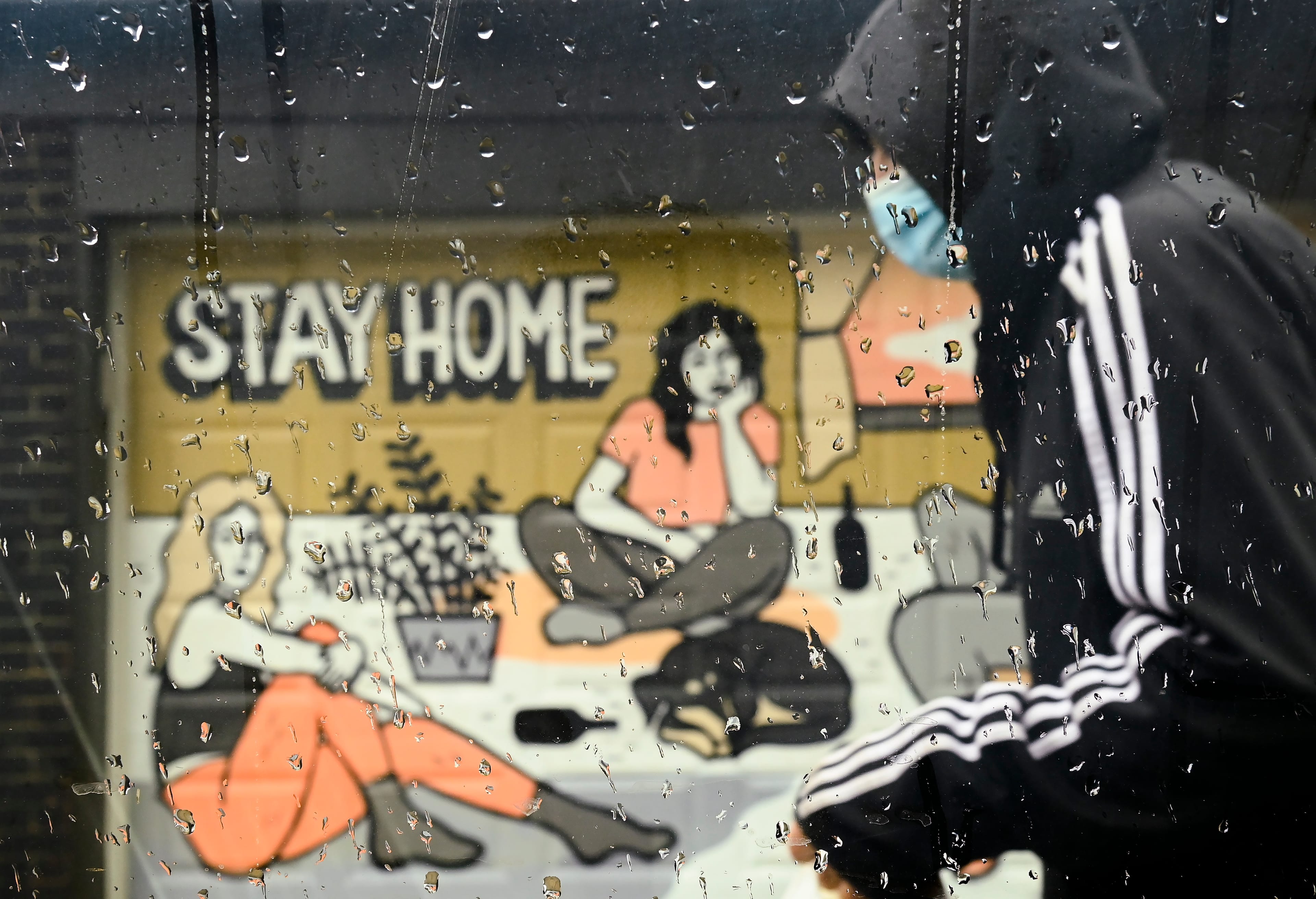 A person walks past a COVID-19 mural in Toronto on April 12, 2021 (Nathan Denette/CP)