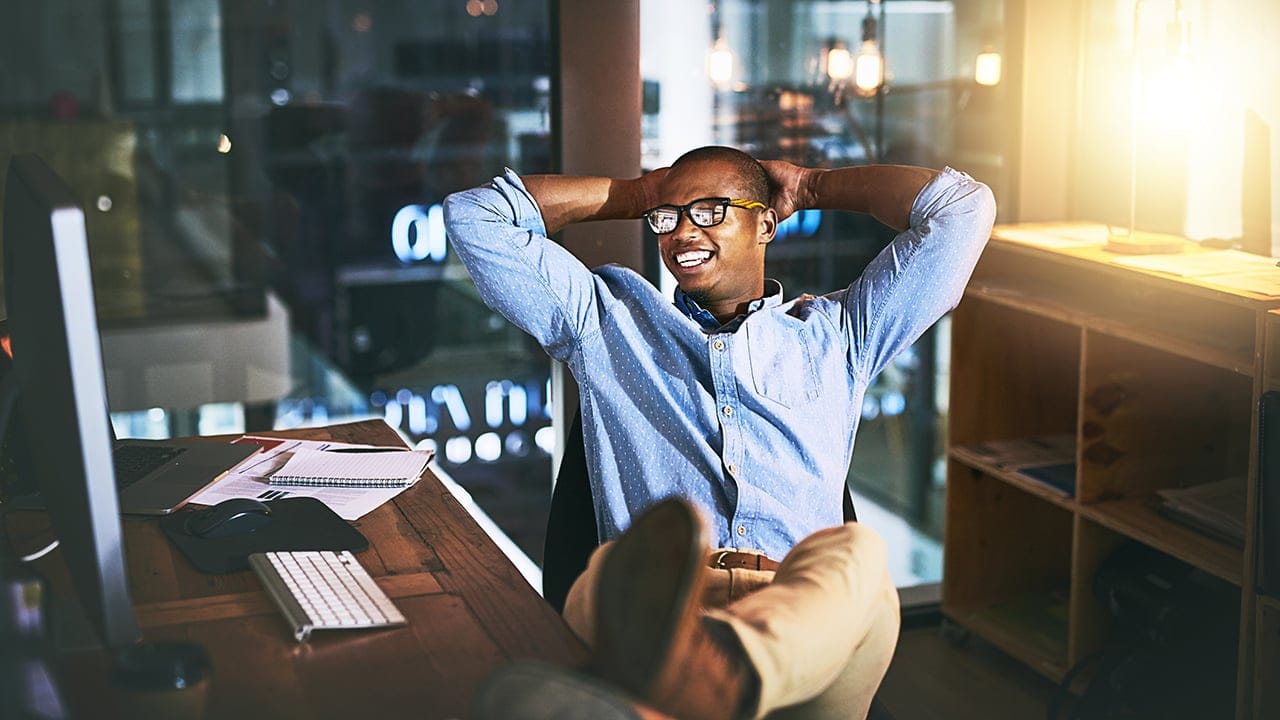 Shot of a young businessman relaxing at his desk during a late night at work