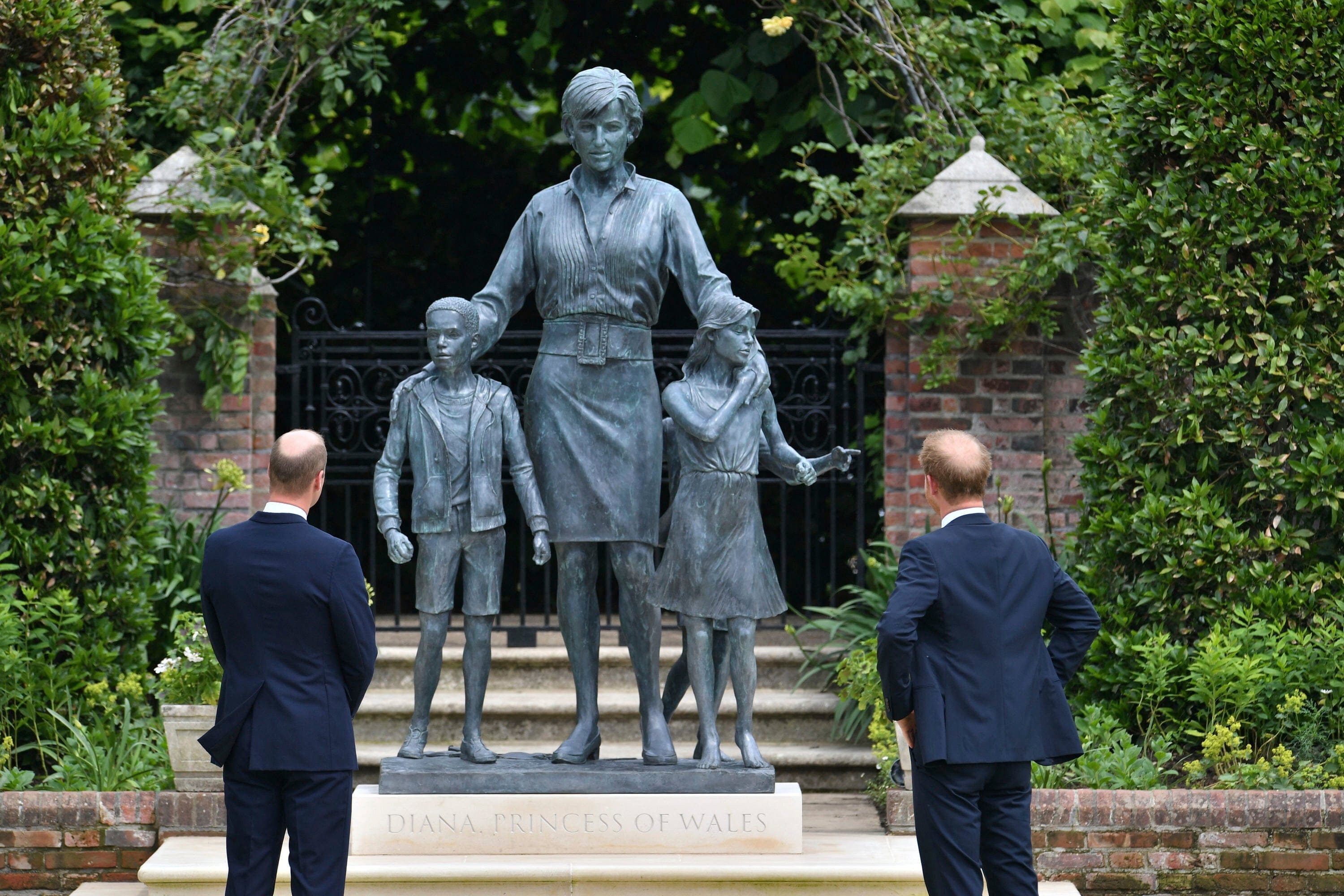Britain's Prince William, left and Prince Harry unveil a statue they commissioned of their mother Princess Diana, on what woud have been her 60th birthday, in the Sunken Garden at Kensington Palace, London, Thursday July 1, 2021. (Dominic Lipinski /Pool Photo via AP)