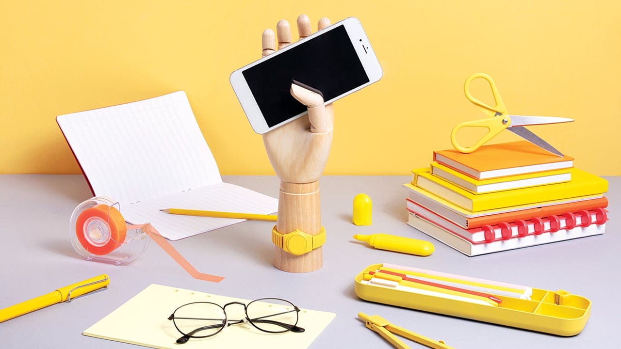 School supplies on desk with smartphone