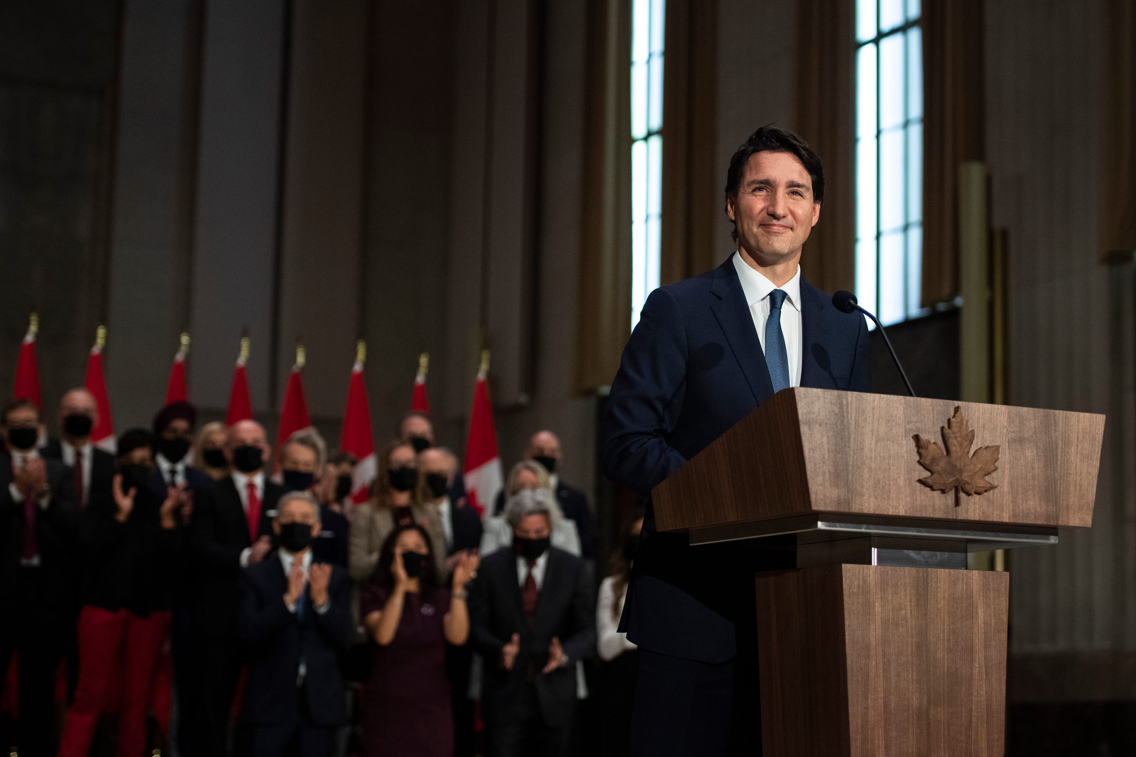 Members of the federal cabinet applaud as Prime Minister Justin Trudeau speaks at a news conference in Ottawa, on Oct. 26, 2021 (Justin Tang/CP)