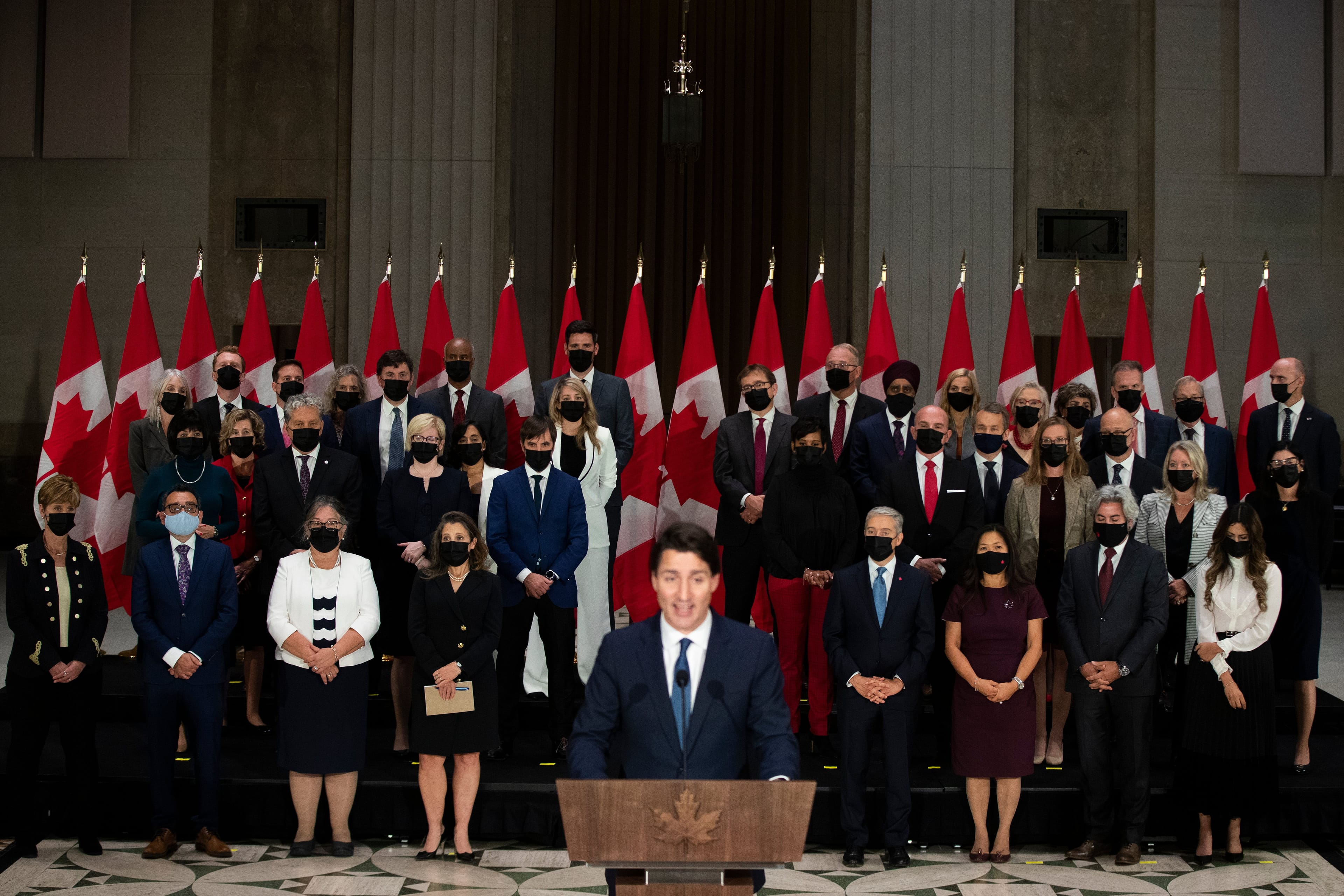 The newly sworn-in federal cabinet listens to Prime Minister Justin Trudeau during a press conference in Ottawa on Oct. 26, 2021 (Lars Hagberg/CP)