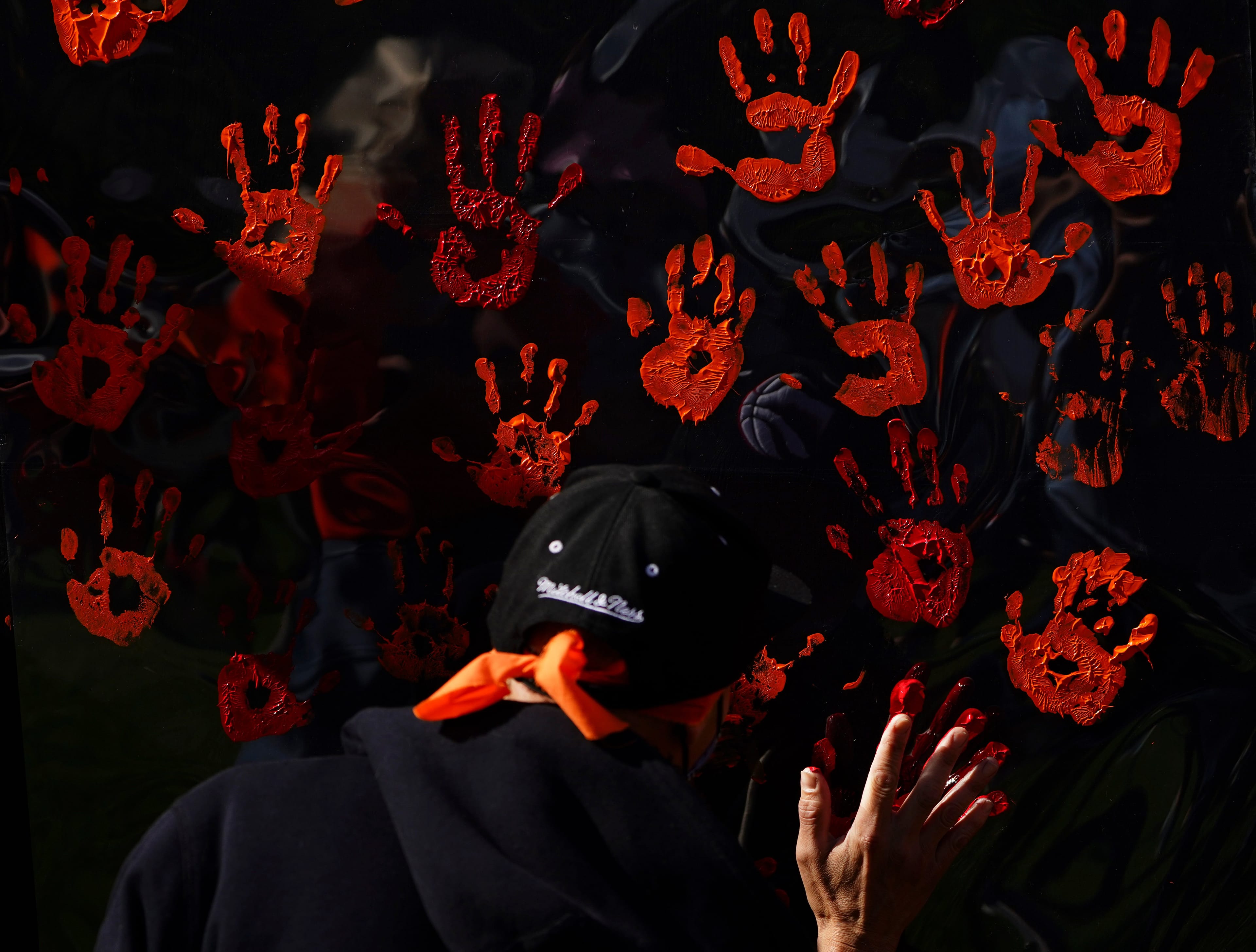 People contribute to a hand painting during the National Day for Truth and Reconciliation in Ottawa on Thursday, Sept. 30, 2021. THE CANADIAN PRESS/Sean Kilpatrick