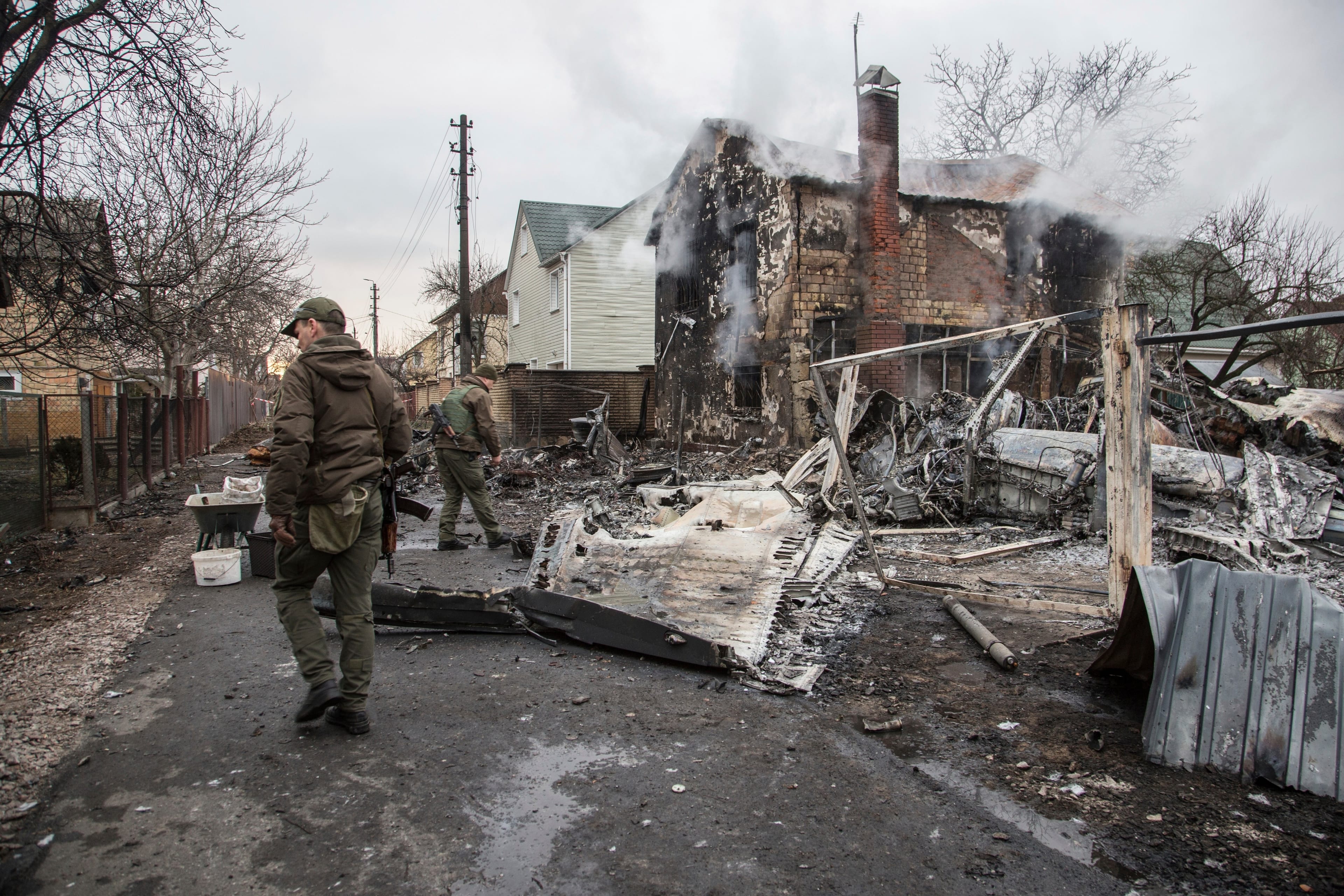 Ukrainian troops examine the scene of a downed aircraft in Kyiv on Friday.(Oleksandr Ratushniak/AP)