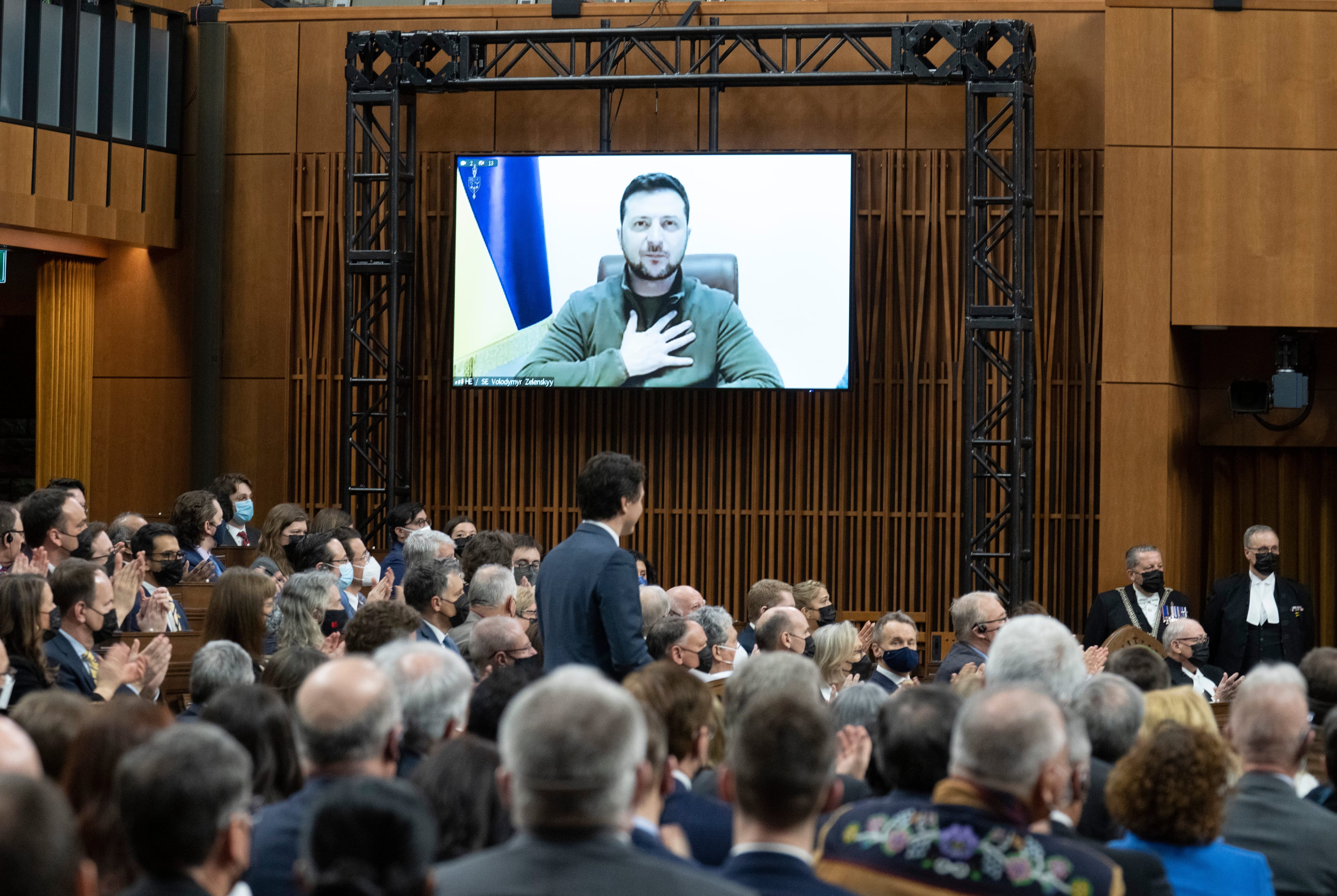 Zelensky places his hand on his chest as he listens to Canadian Prime Minister Justin Trudeau deliver opening remarks before addressing the Canadian parliament, March 15, 2022 in Ottawa. (Adrian Wyld/The Canadian Press)