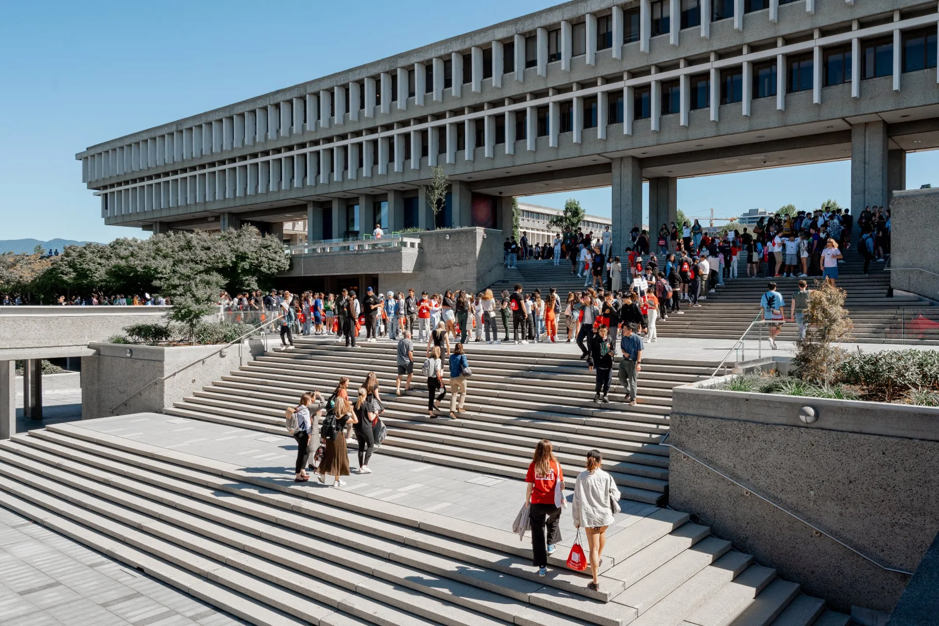 wide angle shot of a building with multiple steps and people walking up and down them