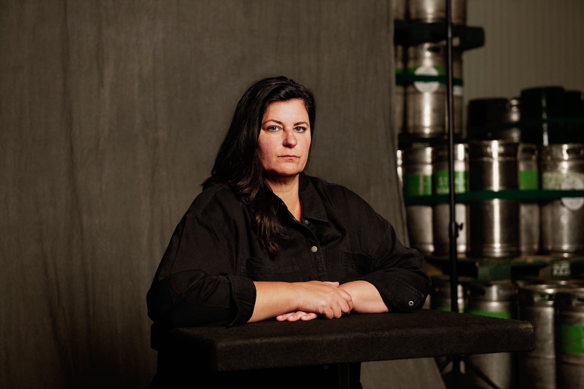 A woman in a black shirt photographed against a dark grey backdrop