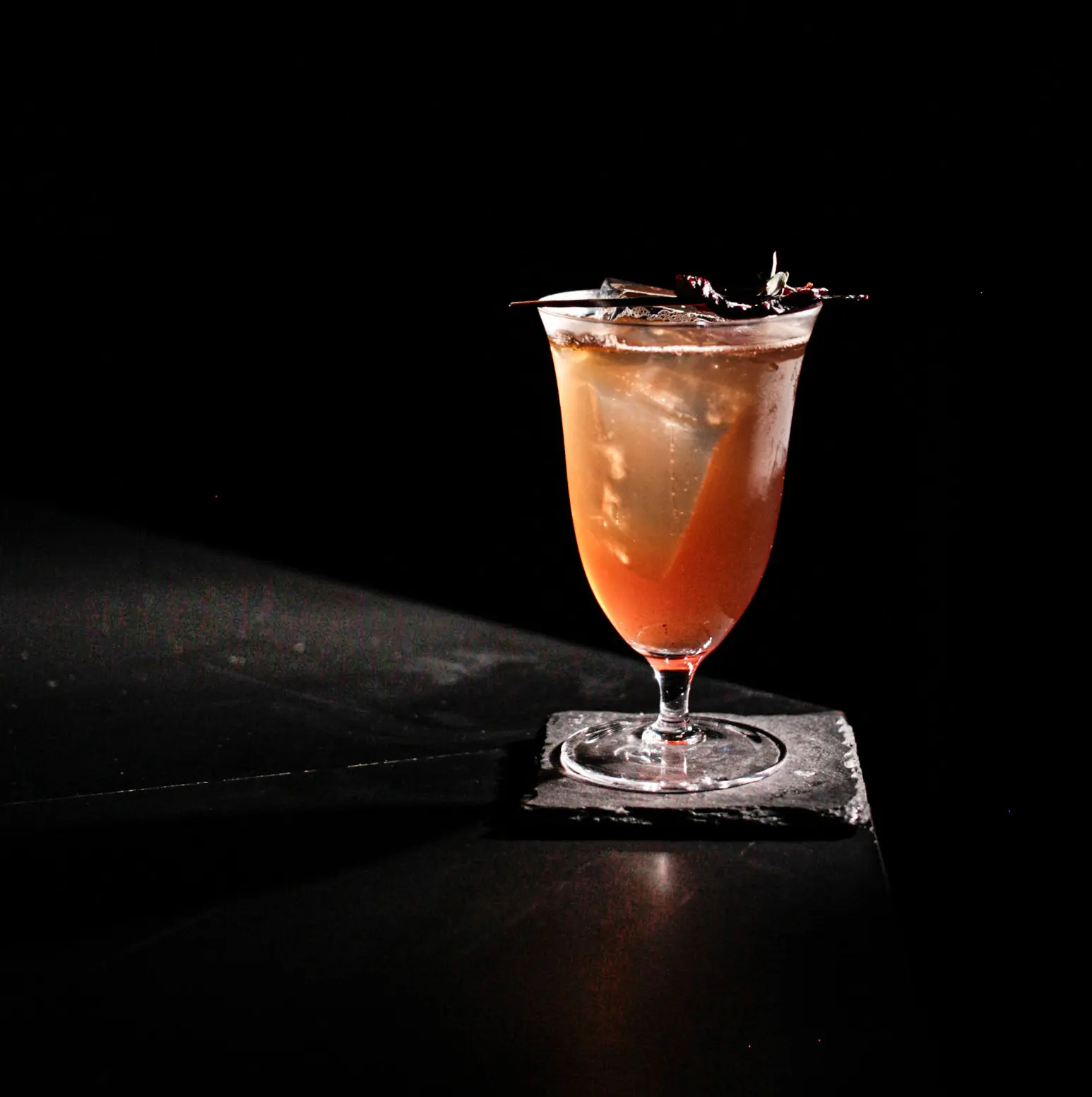 An orange drink in a crystal glass