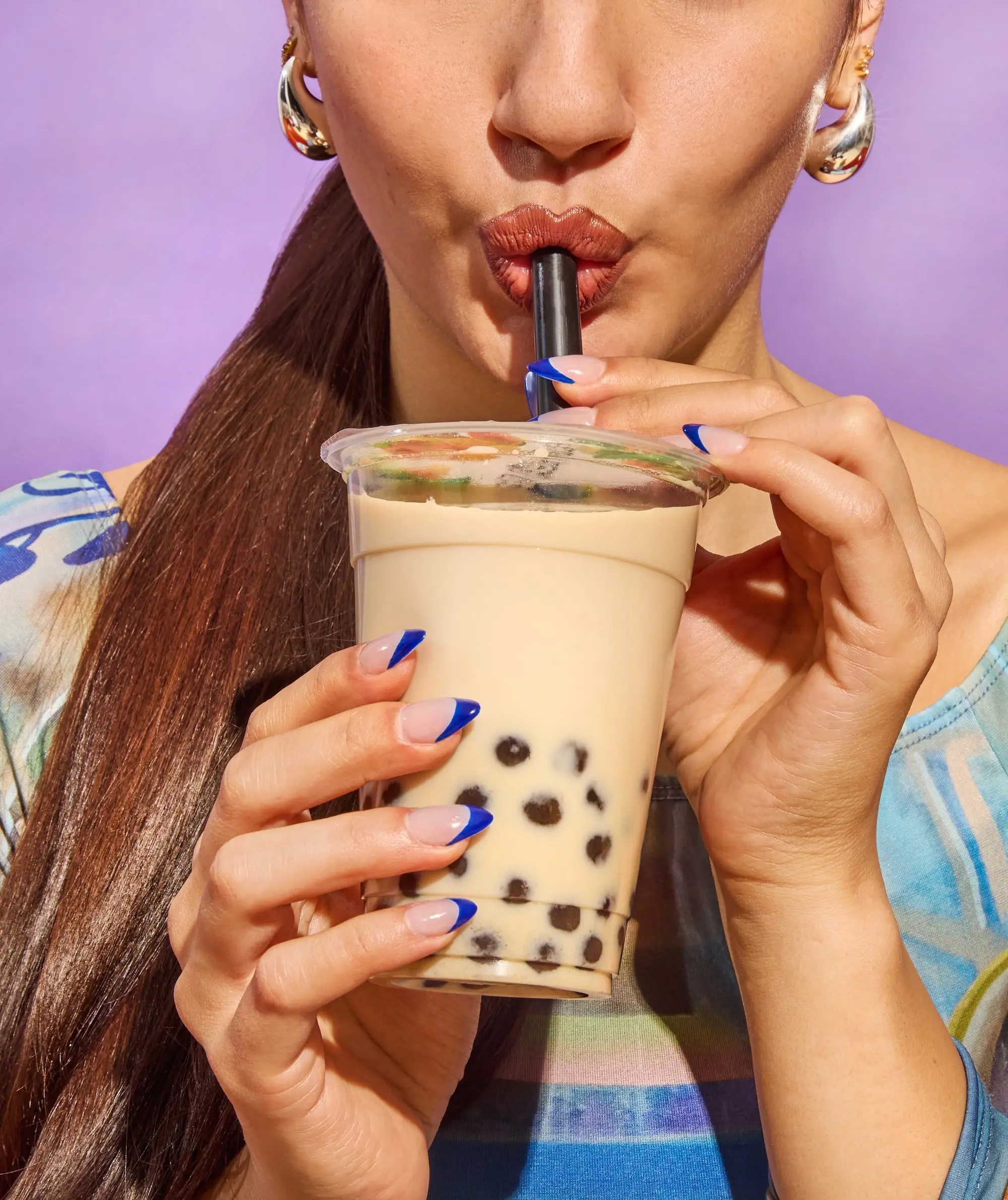 A close-up shot of a woman indulging in bubble tea