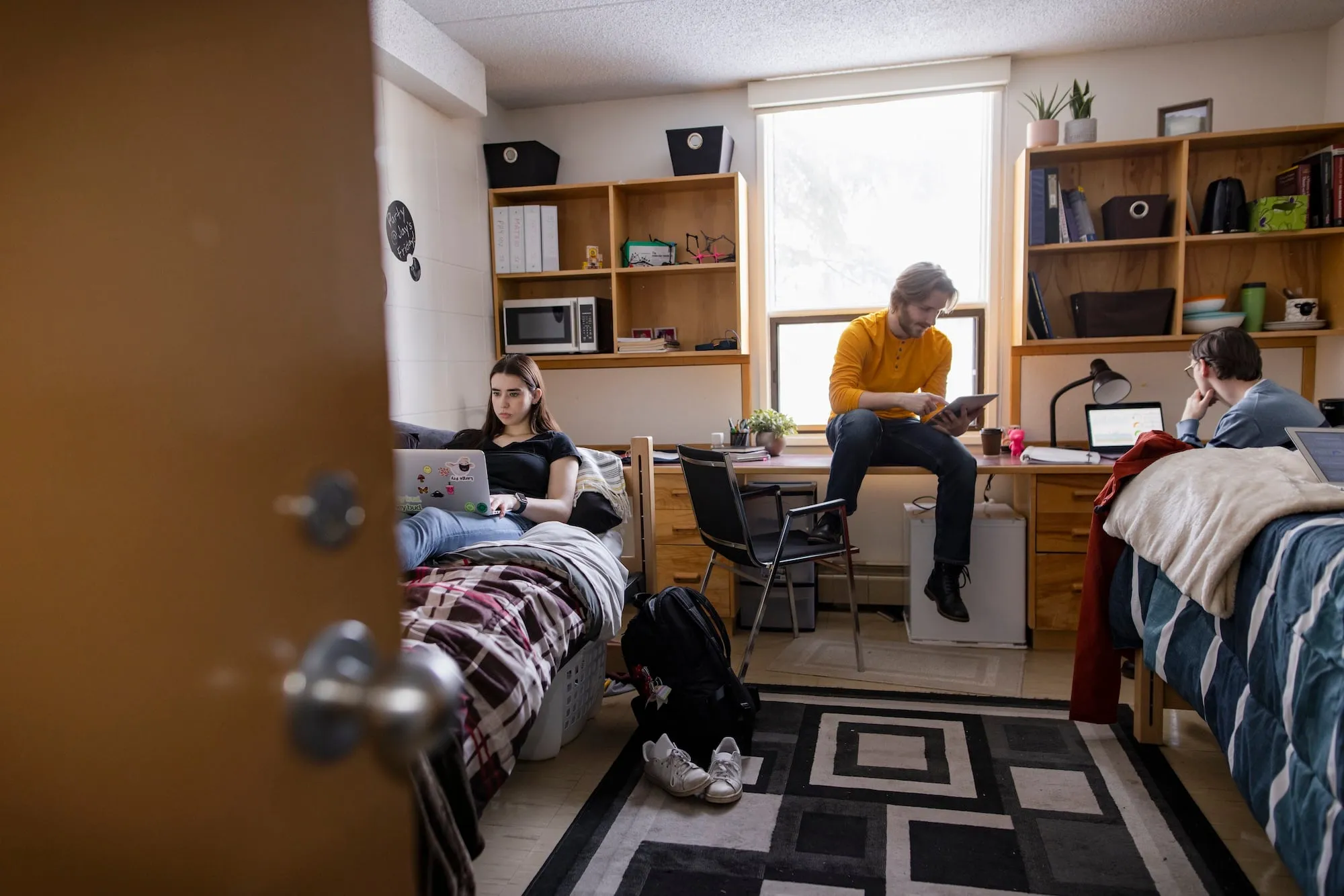 A student sitting in a dorm room bed