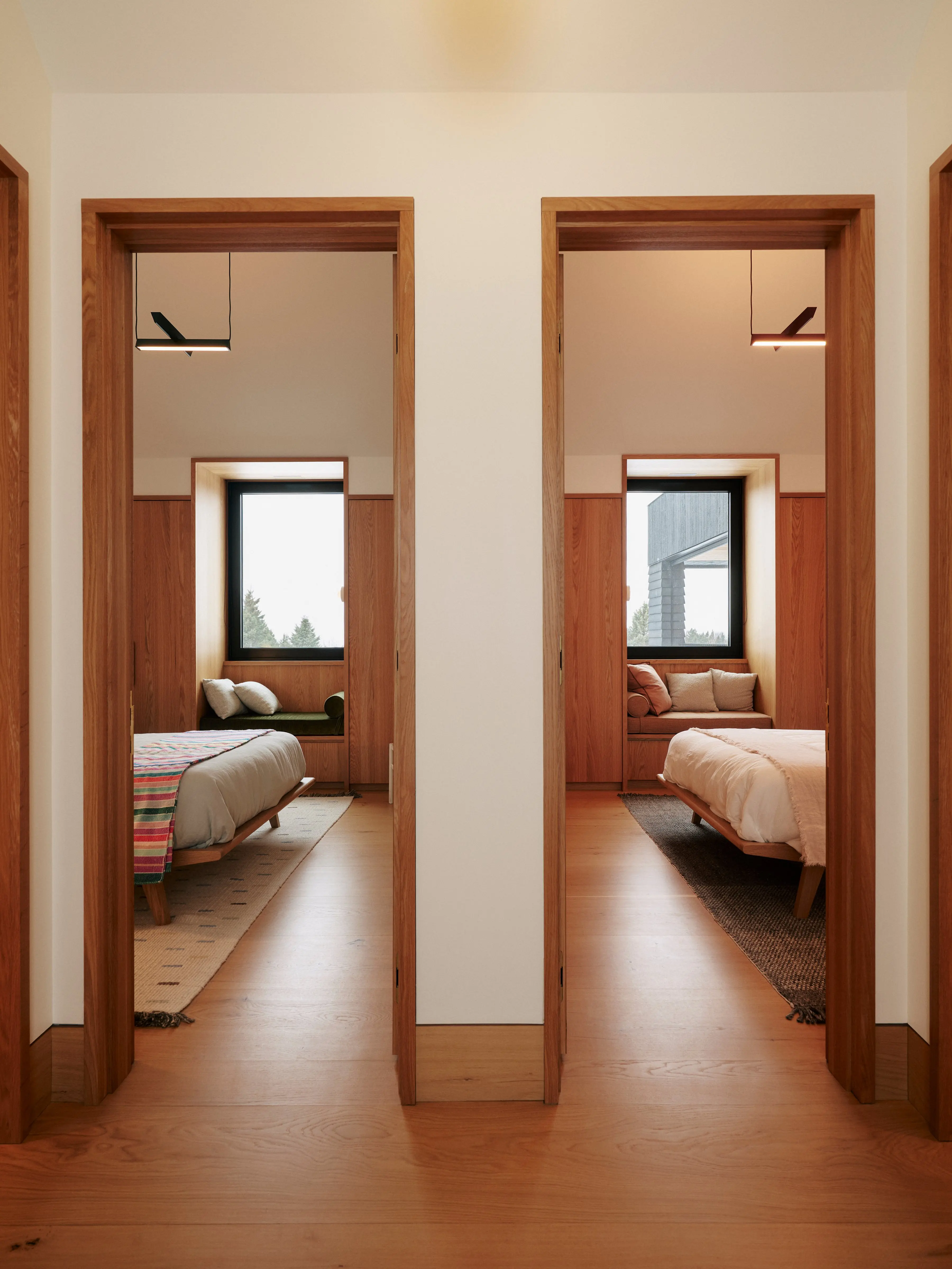 Looking through two bedroom doors. Each have windows in the same place and beds facing opposite directions