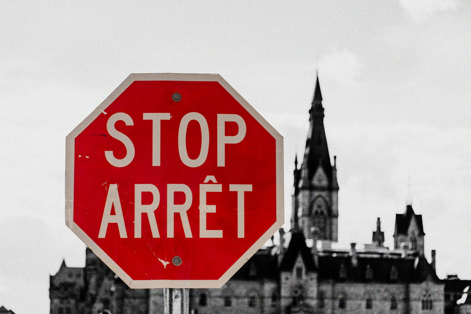 A bilingual stop sign in front of Parliament Hill