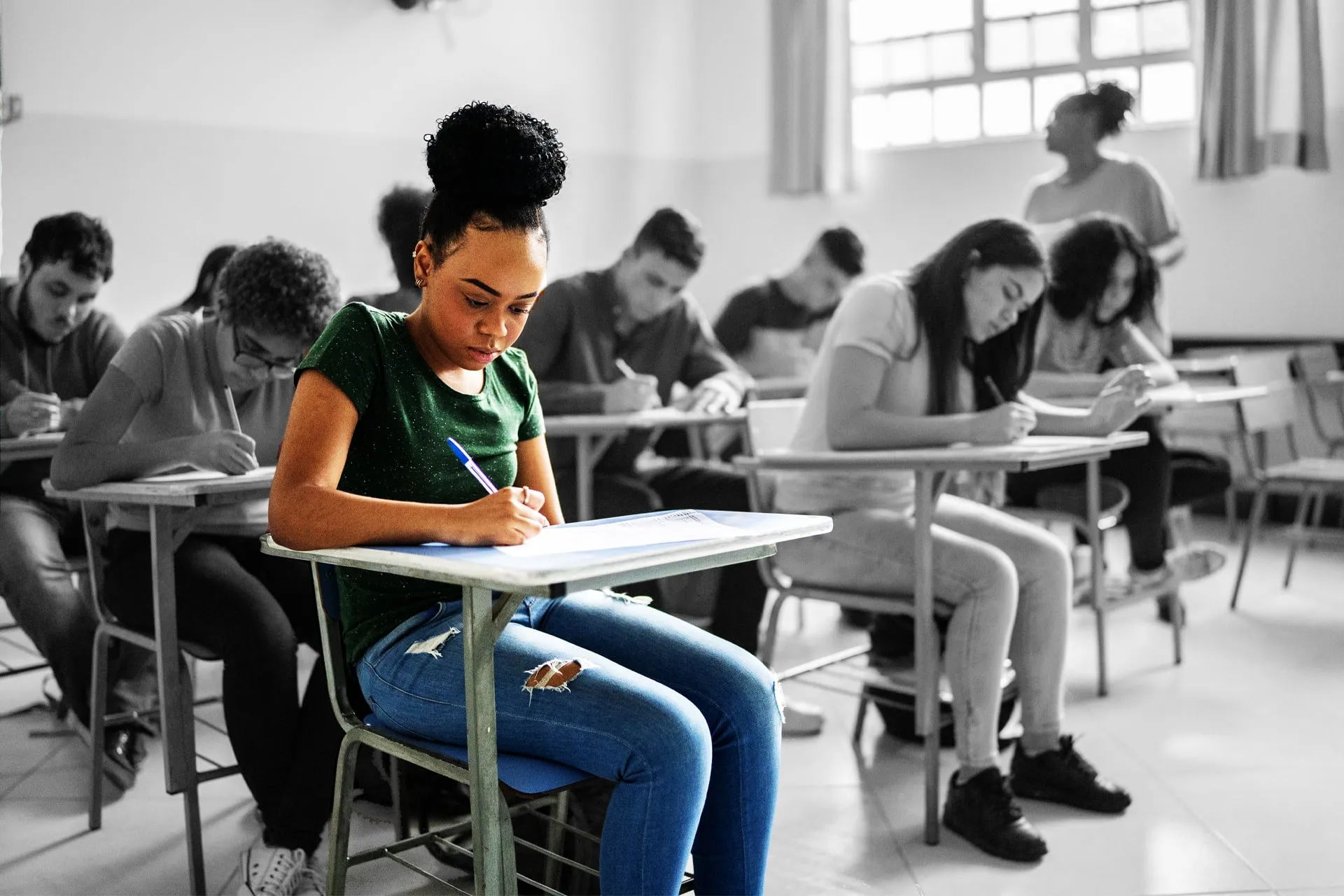 A classroom full of students, but only one is in colour and the rest are black-and-white