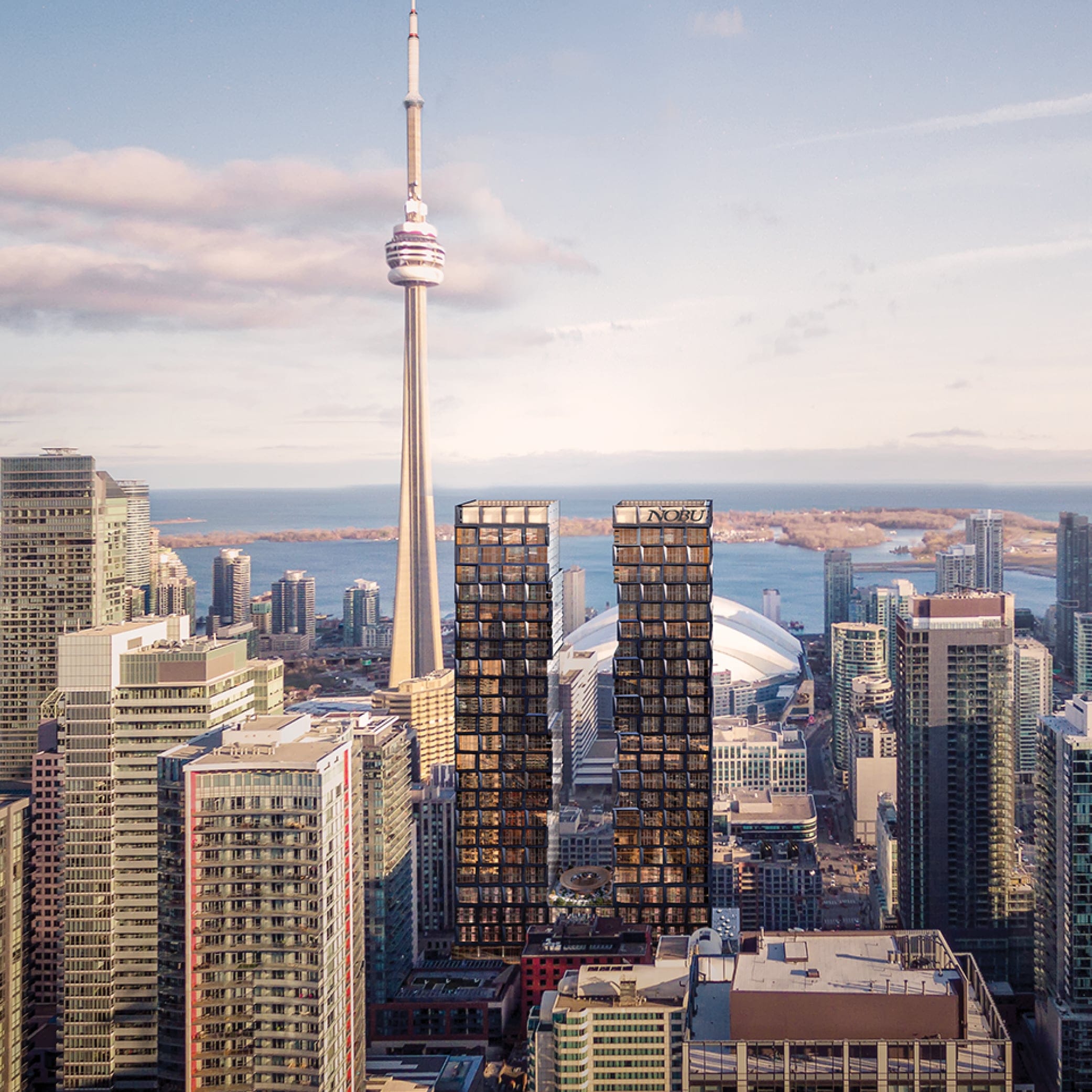 An aerial wide shot captures the Nobu Hotel twin tower. surrounded by the other tall buildings including the CN Tower. Behind them are the Lake Ontario and the Toronto Island.