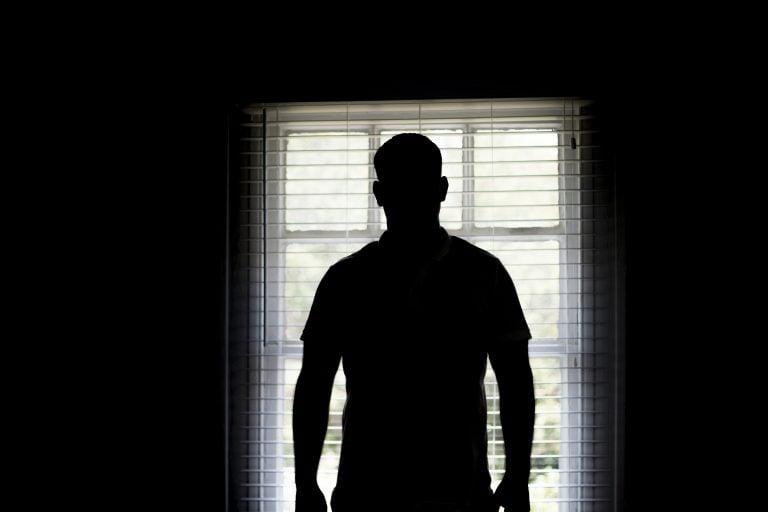 Man in silhouette by window