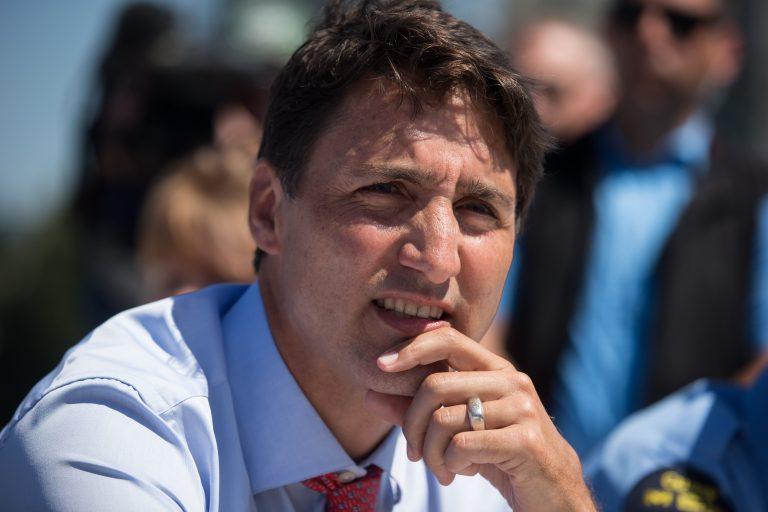 Prime Minister Justin Trudeau listens while talking with members of the Canadian Coast Guard after an announcement at the Kitsilano Coast Guard Base, in Vancouver, on Monday July 29, 2019.