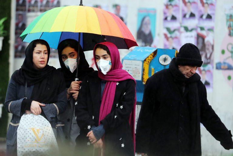 Iranian women wearing masks wait for a taxi in a street of Tehran, Iran, Feb. 20, 2020. According to the Ministry of Health, two people diagnosed with coronavirus died in the city of Qom, central Iran. The disease caused by the virus (SARS-CoV-2) has been officially named COVID-19 by the World Health Organization (WHO). (ABEDIN TAHERKENAREH/EPA/CP)