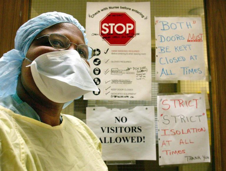 A nurse wears the protective clothing used when treating patients with atypical pneumonia (SARS) outside the door of a quarantined patient diagnosed with the illness in a ward at Sunnybrook and Women's Hospital in Toronto on March 17, 2003. Ontario health officials say some front-line workers scarred by their experience with SARS are stepping up precautions against the novel coronavirus.THE CANADIAN PRESS/Kevin Frayer