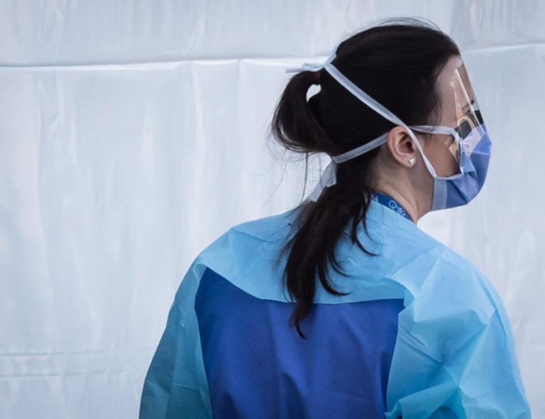 A hospital worker wearing a face shield and mask is seen at a COVID-19 assessment centre for staff at Lions Gate Hospital, in North Vancouver, on Thursday, March 19, 2020. THE CANADIAN PRESS/Darryl Dyck