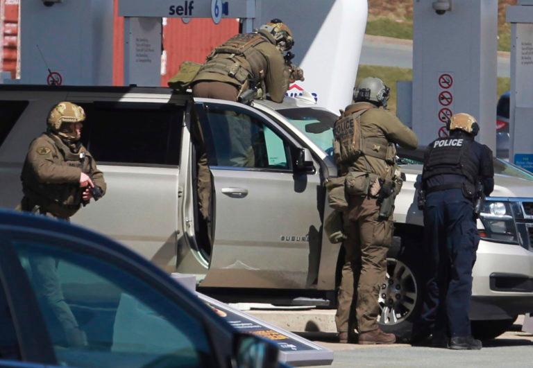 RCMP officers surround a suspect at a gas station in Enfield, N.S., on April 19, 2020 (Tim Krochak/The Canadian Press via AP, File)