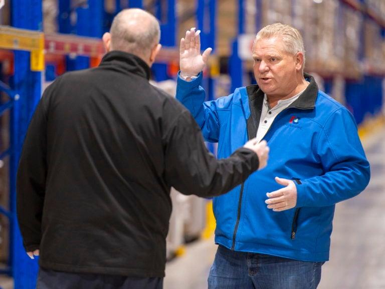 Ontario Premier Doug Ford talks with Metro Supply Chain Group COO Murray Brabender while inspecting personal protective equipment supplies at a warehouse in Toronto on Mar. 29, 2020. (Frank Gunn/CP)