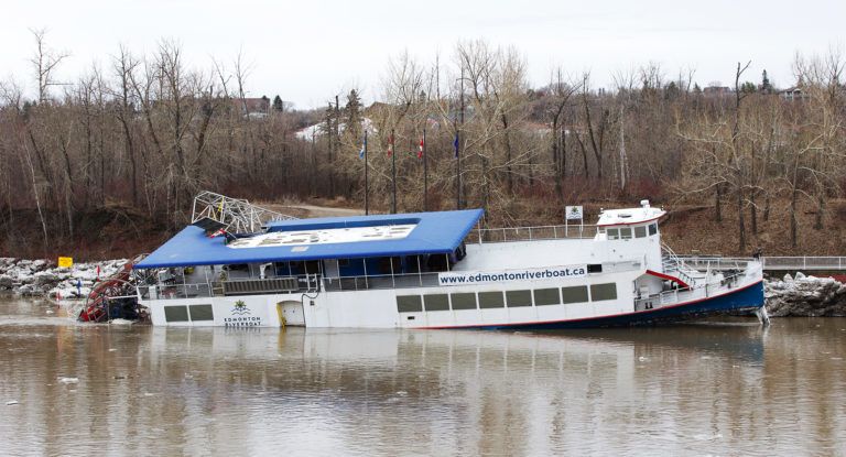 The Edmonton River boat is listing heavily to starboard at the stern in the North Saskatchewan River at Rafters Landing. (Greg Southam/Postmedia)