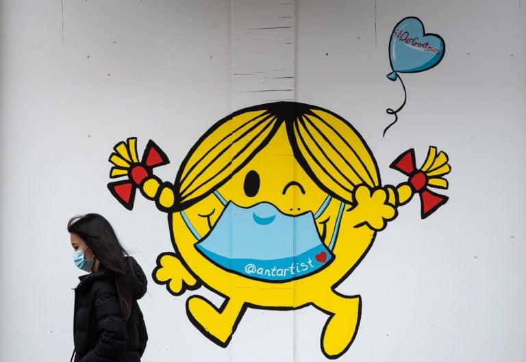 A mural in Vancouver shows author and illustrator Roger Hargreaves's Little Miss Sunshine character wearing a face mask (Darryl Dyck/CP)