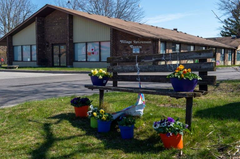 Flowers sit on a bench in front of Orchard Villa care home in Pickering, Ont. on Apr. 27, 2020. Ontario Premier Doug Ford has called in operational support from the Canadian Armed Forces for Orchard Villa and five other long-term care homes in Ontario (Frank Gunn/CP)