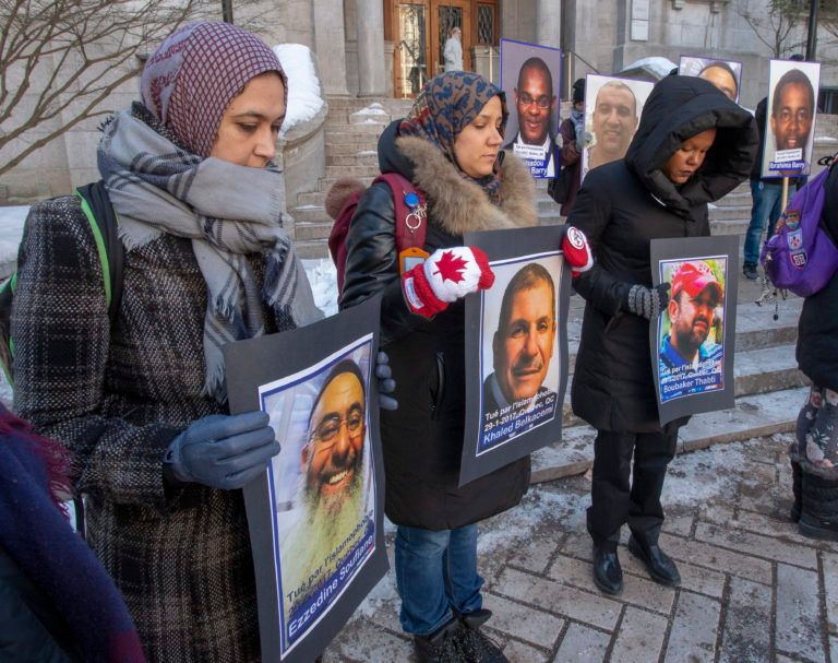 People hold photos of the victims during a vigil on Jan. 29, 2020 in Montreal to commemorate the third anniversary of the mosque shooting in Quebec City that left six people dead. (Ryan Remiorz/CP)