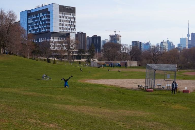 A man does a headstand in Riverdale Park East in Toronto., on Apr. 20, 2020. (Rachel Verbin/CP)