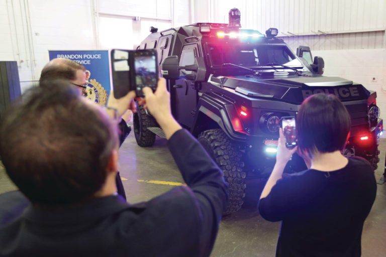 Guests take photos of the Brandon Police Service's new armoured response vehicle during the vehicle's unveiling at Assiniboine Community College's Public Safety Training Centre at their Victoria Avenue East campus on Thursday. (Tim Smith)