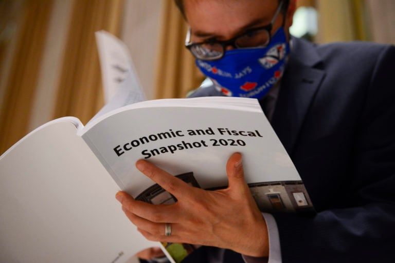 A copy of the federal government's Economic and Fiscal Snapshot 2020 is thumbed through as reporters take part in a media lock-up for the in Ottawa on Jul. 8, 2020. (Sean Kilpatrick/CP)